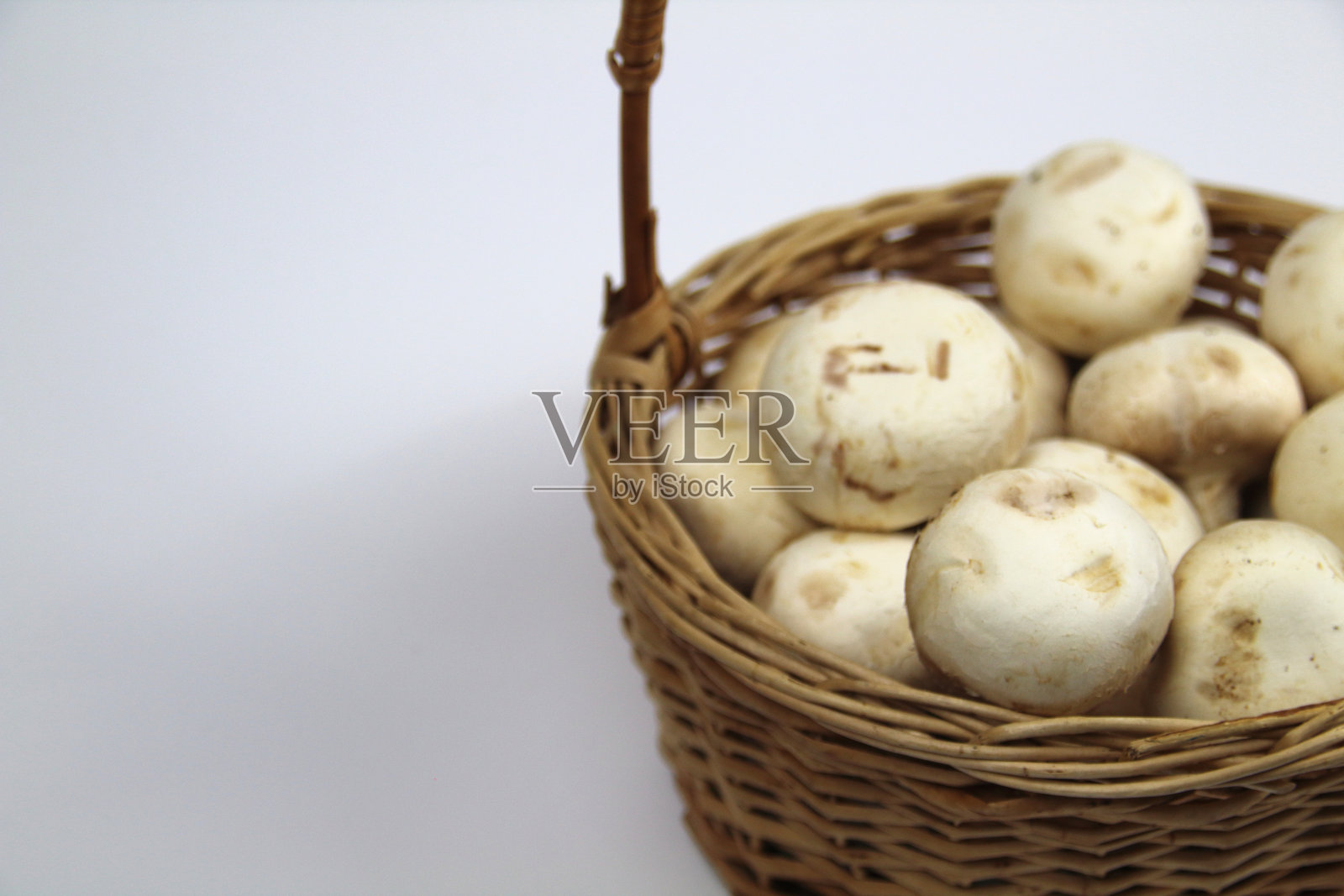 白色背景上的篮子里的蘑菇照片摄影图片