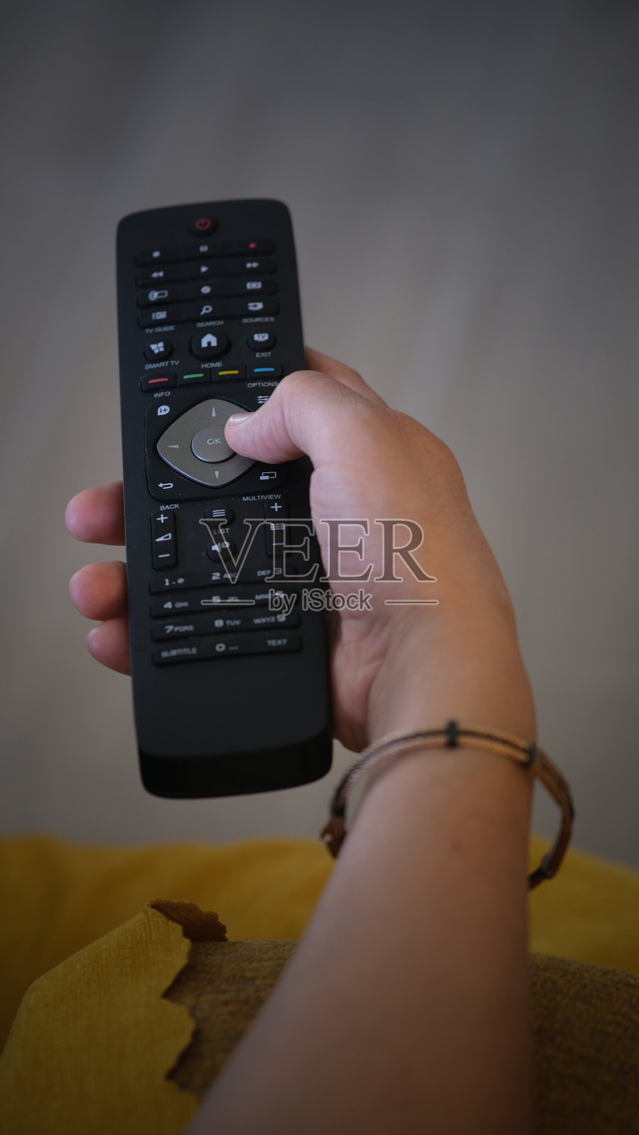 手握电视遥控器照片摄影图片