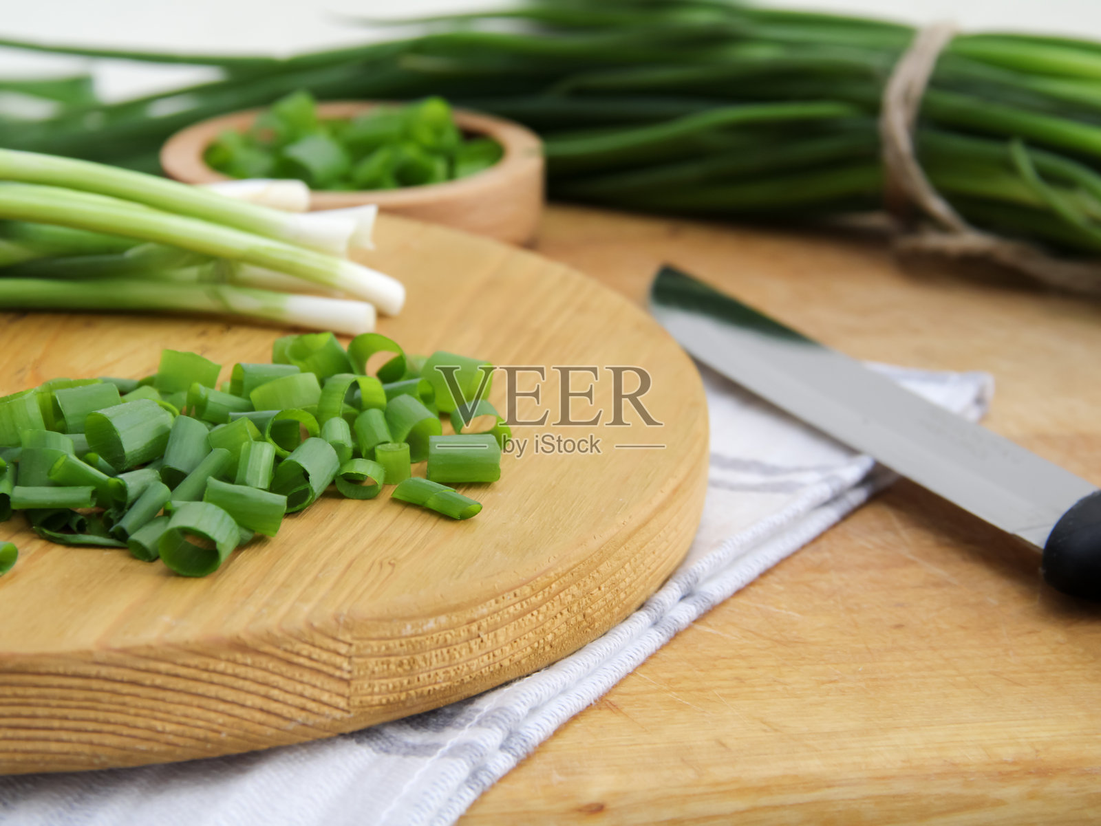 切菜板上的切碎绿叶蔬菜和刀照片摄影图片