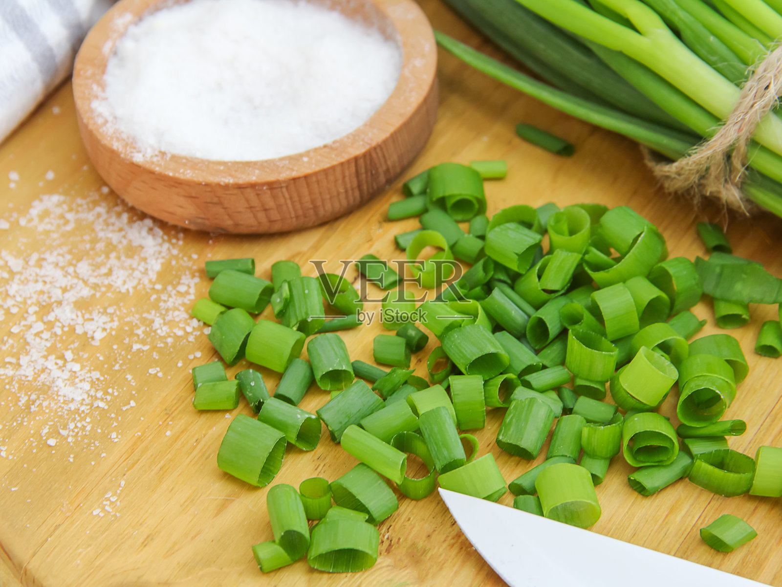 切好的青葱、葱杆和盐放在铺有木板的桌子上，俯视图照片摄影图片