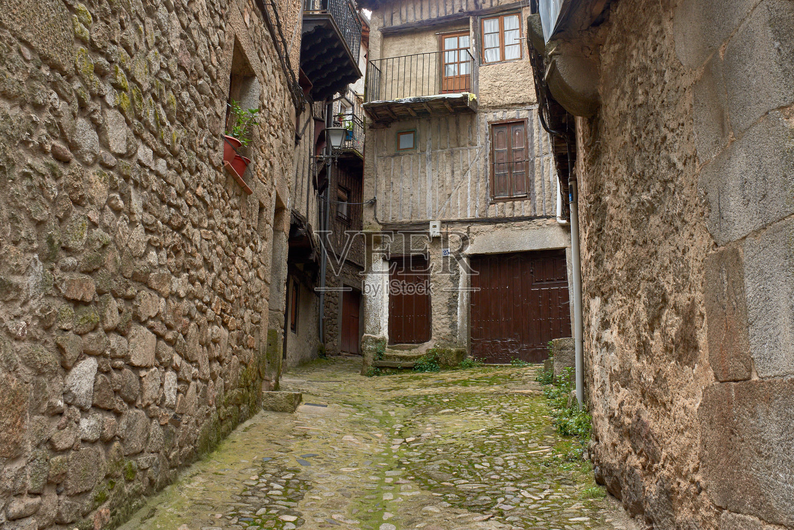 拉尔贝尔卡，萨拉曼卡的一条狭窄街道上的半木结构和石材外立面的传统建筑照片摄影图片