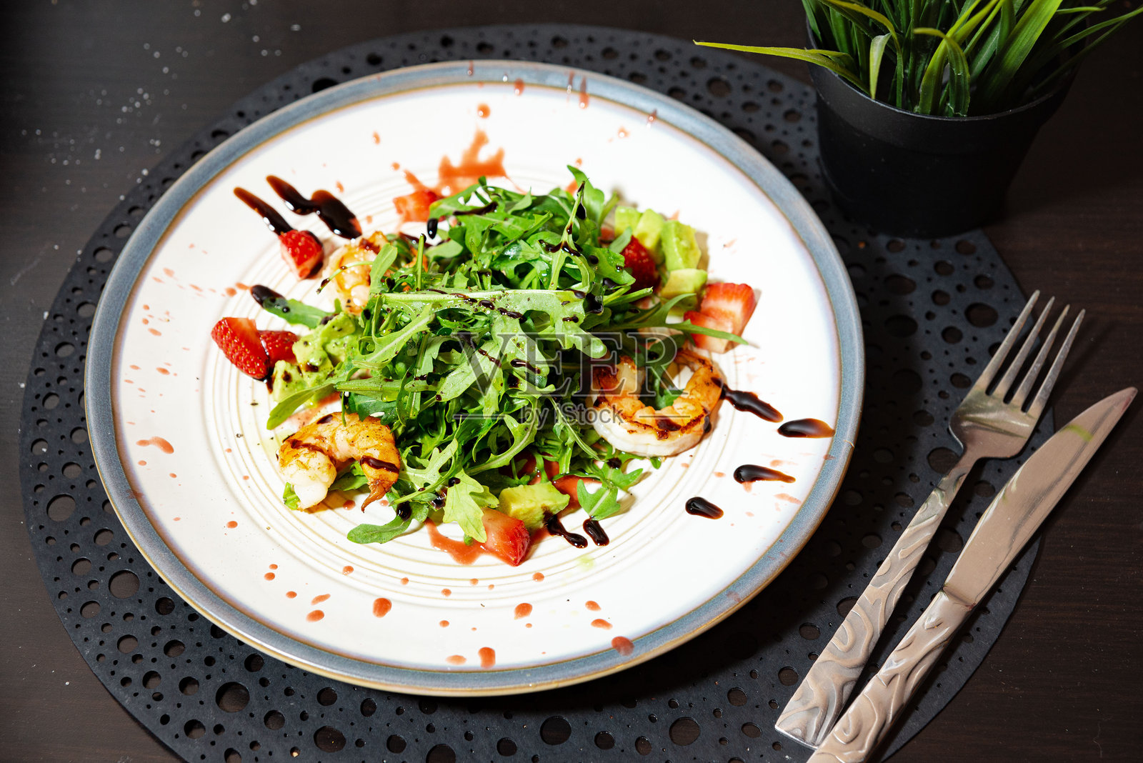 美味的虾仁沙拉配草莓和芝麻菜。照片摄影图片