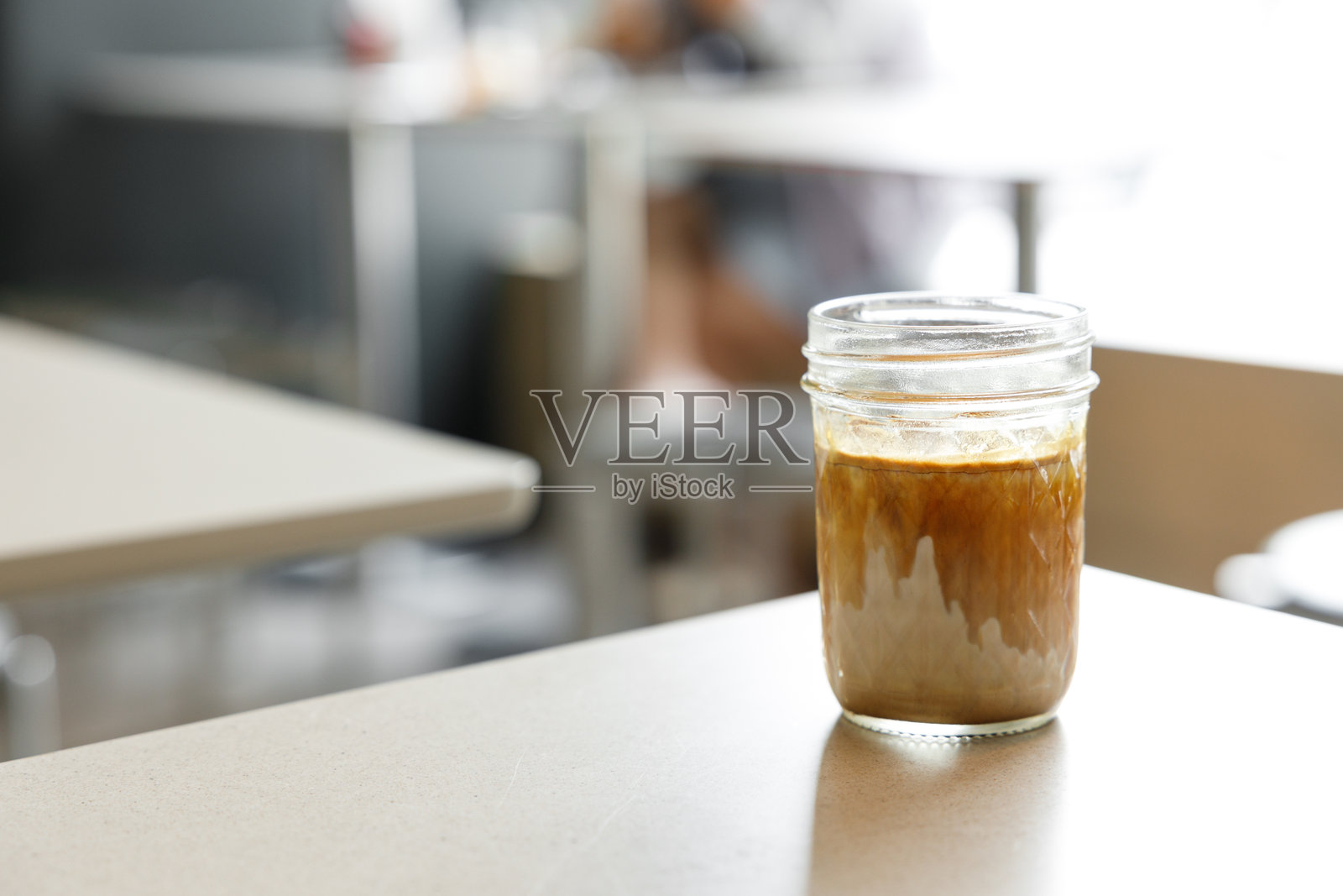 窗边桌子上的一杯脏咖啡和牛奶。照片摄影图片