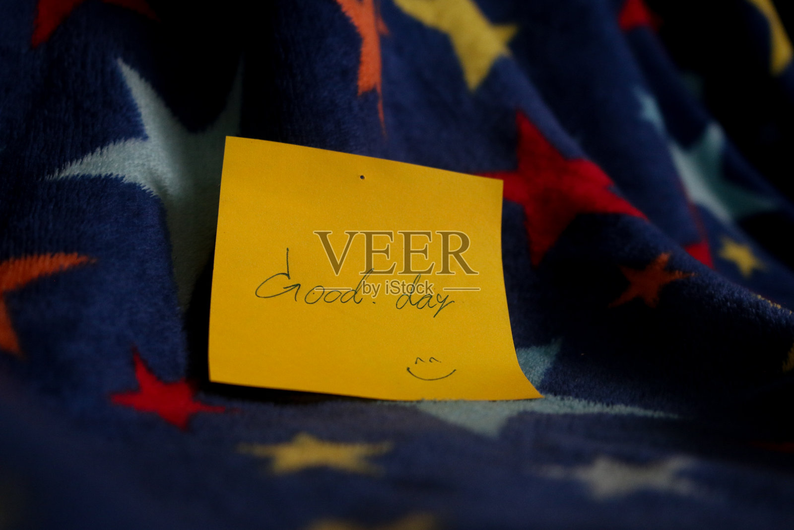 模糊的蓝色背景上有多彩的星星图案，附有便签纸上的文字。新年、派对、圣诞主题。照片摄影图片