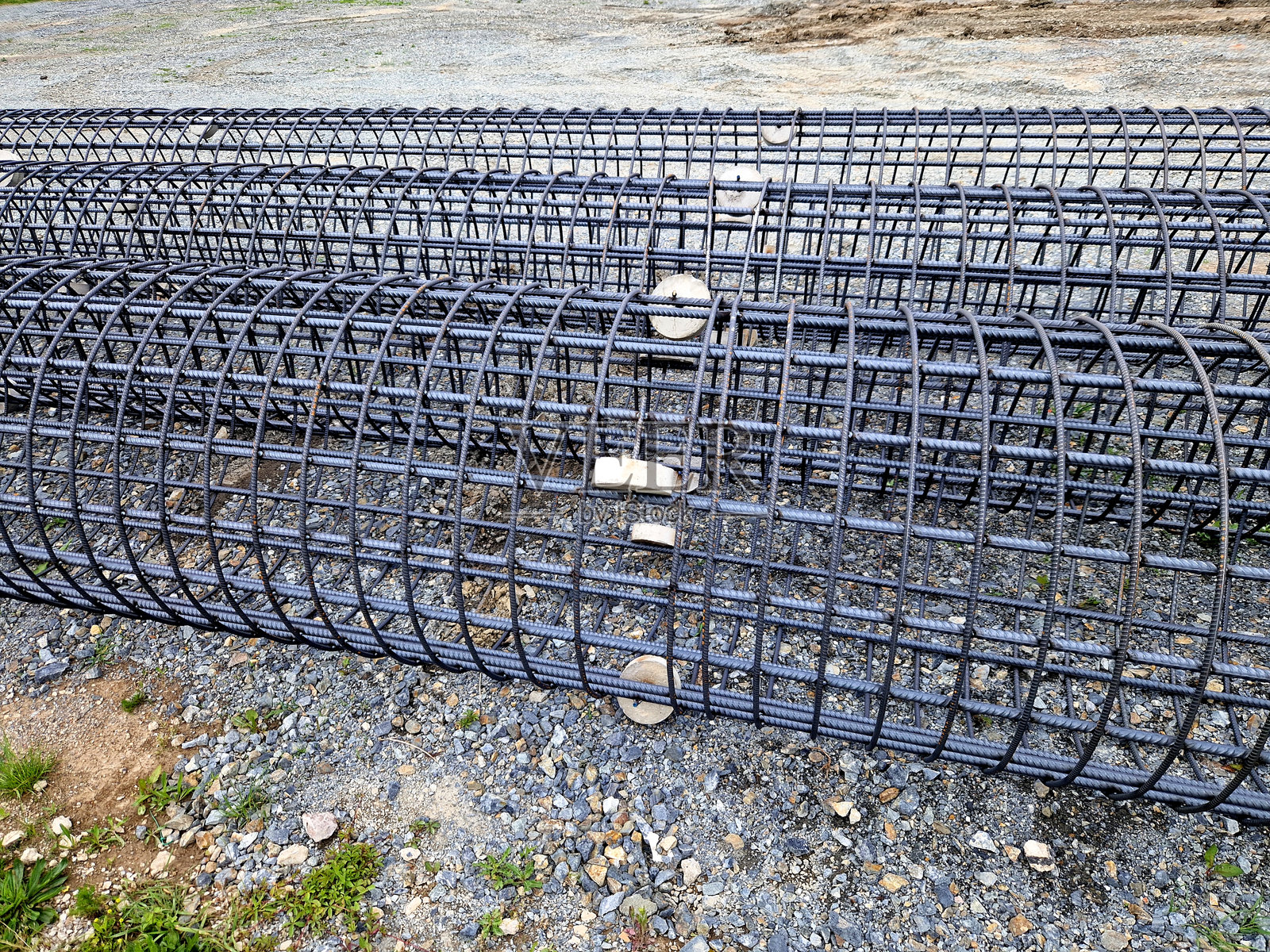 建筑基础网格中的钢筋混凝土圆柱杆结构。桩基础填充混凝土。滚轮允许地下插入，锚固。照片摄影图片