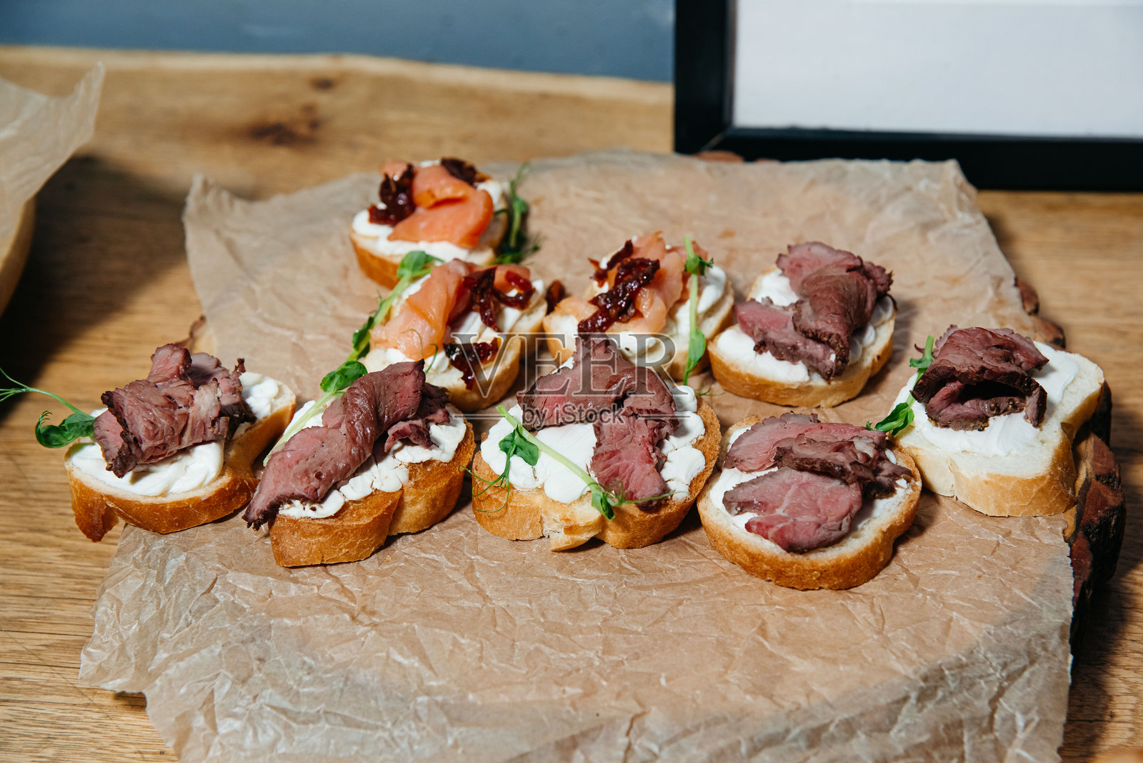 美味的烤牛肉和三文鱼开胃小点心。照片摄影图片