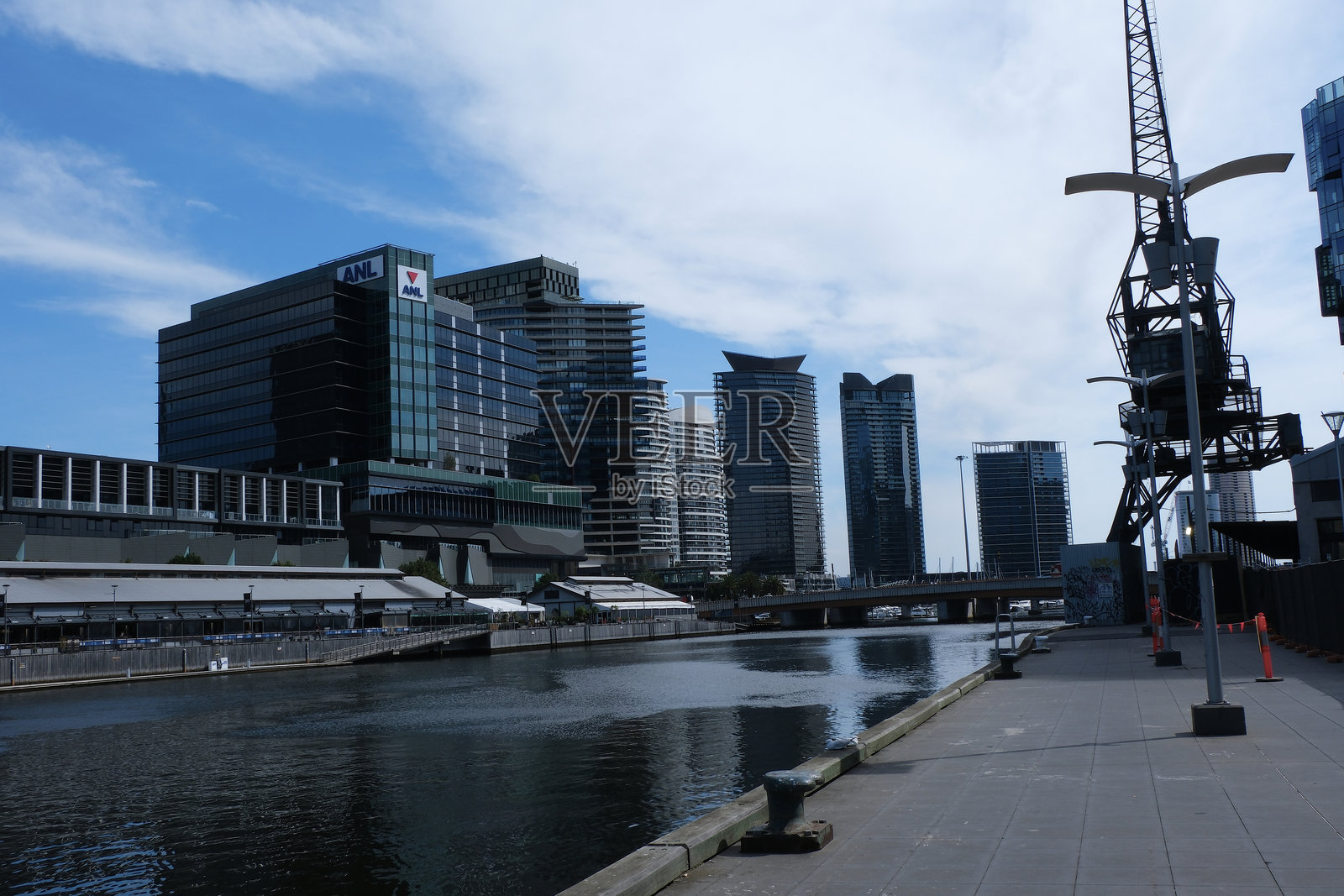 雅拉河与工业纪念碑港口起重机以及澳大利亚墨尔本商业中心的摩天大楼。照片摄影图片