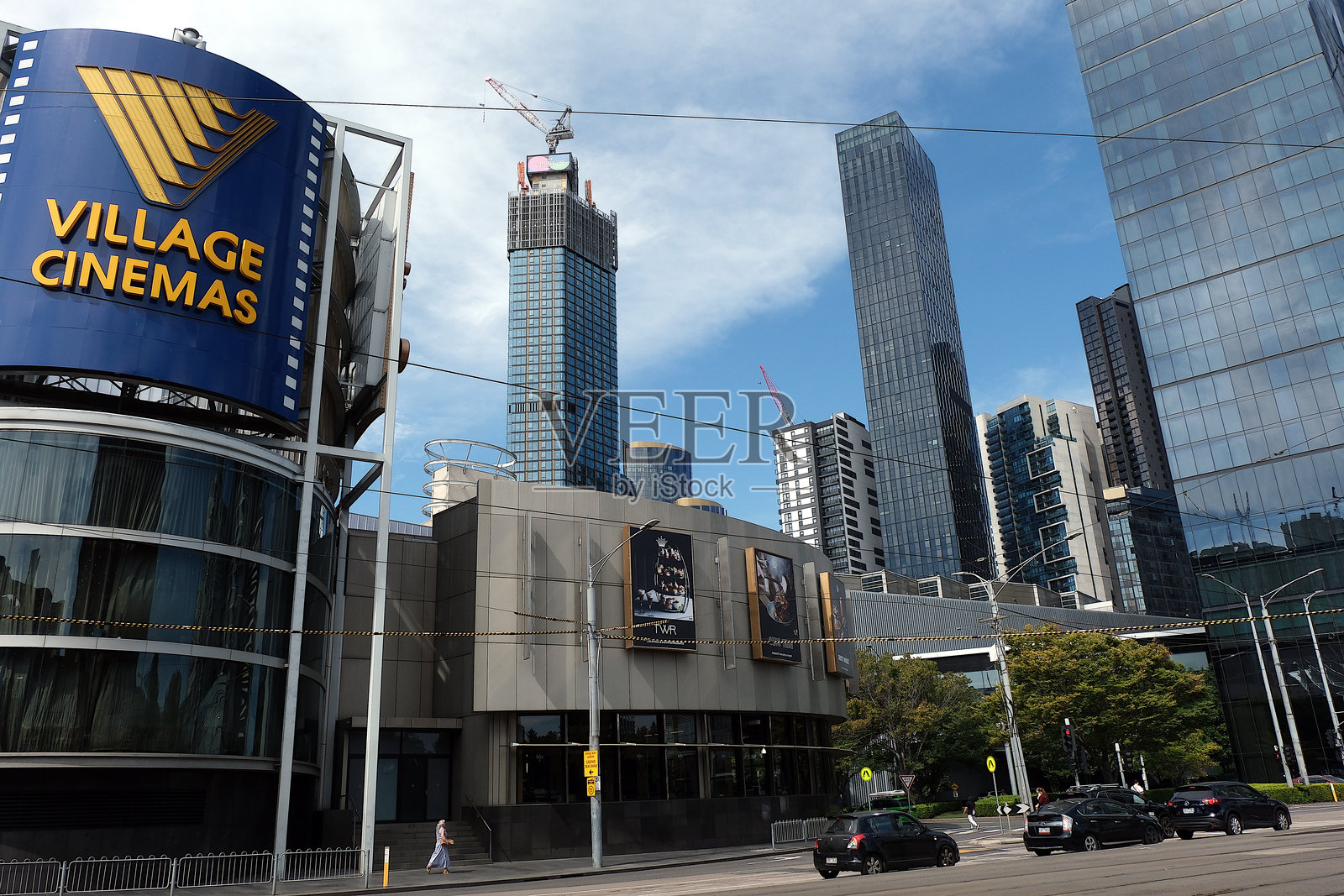 从繁忙街道上看到的澳大利亚墨尔本商业中心的村庄电影院和摩天大楼。照片摄影图片