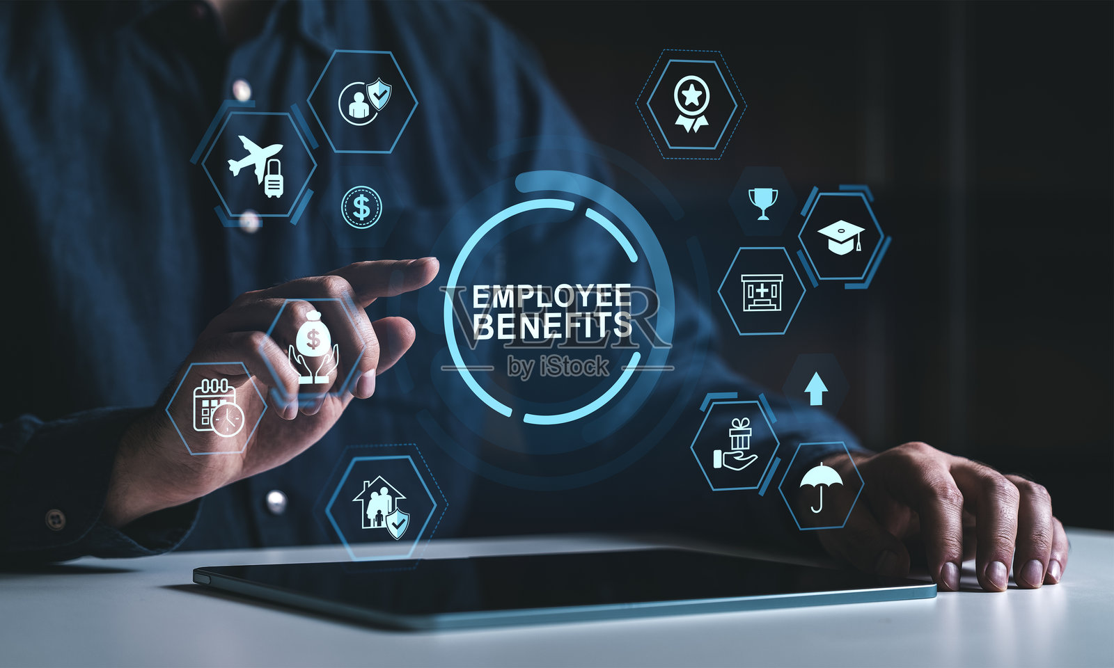 商人正在与虚拟员工福利图标和数字符号互动，界面在平板电脑上方的黑色背景上呈现出未来感。照片摄影图片