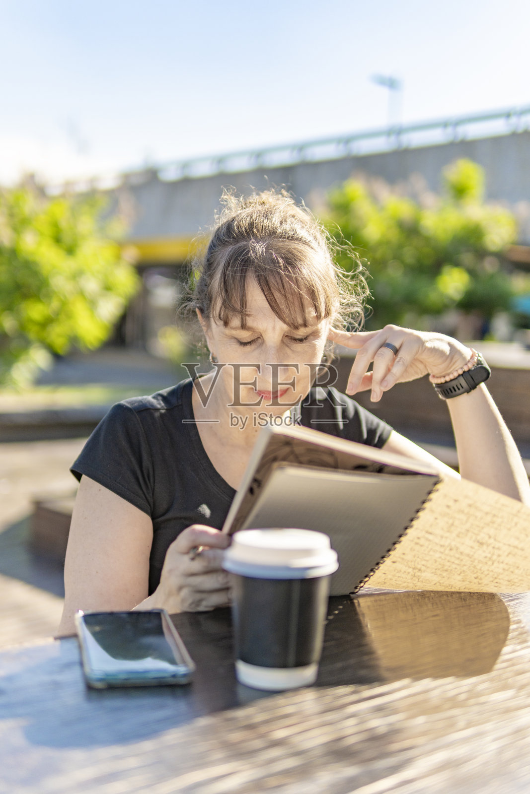 一位老年女性在户外专注于她的笔记照片摄影图片