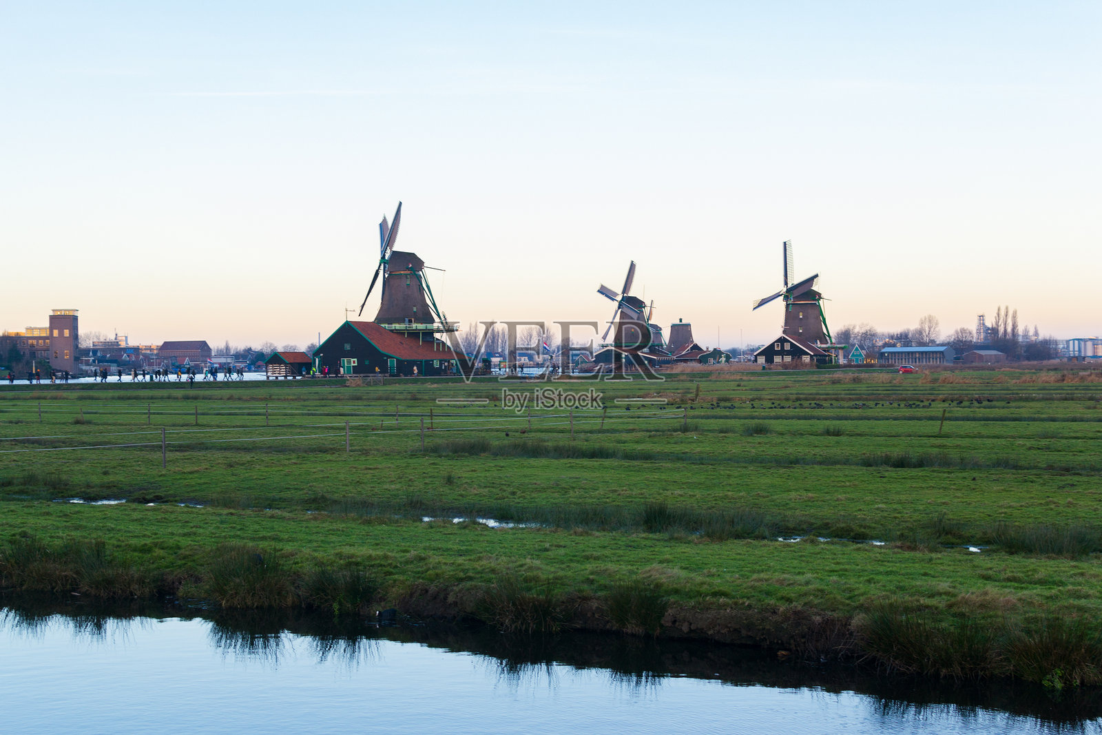 绿色草地上的风车，历史建筑。黄昏时分传统荷兰的如画景象。旅游目的地。照片摄影图片