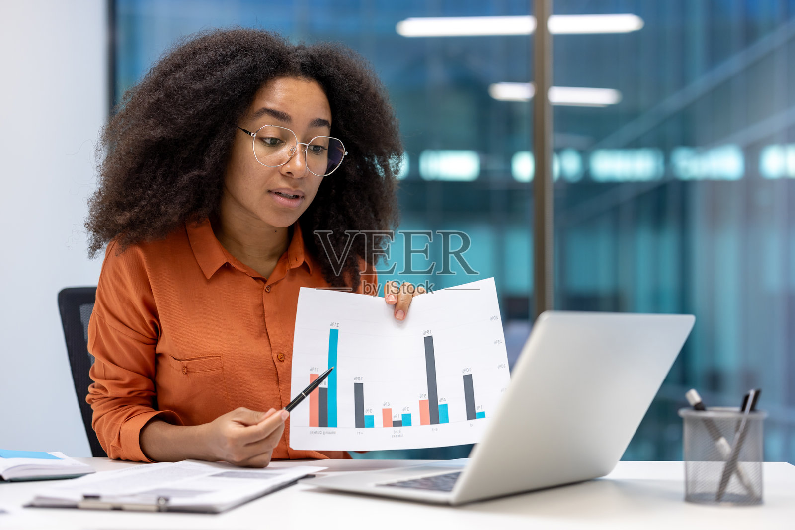 一位非裔美国女性在办公室的视频会议中展示一张图表。照片摄影图片