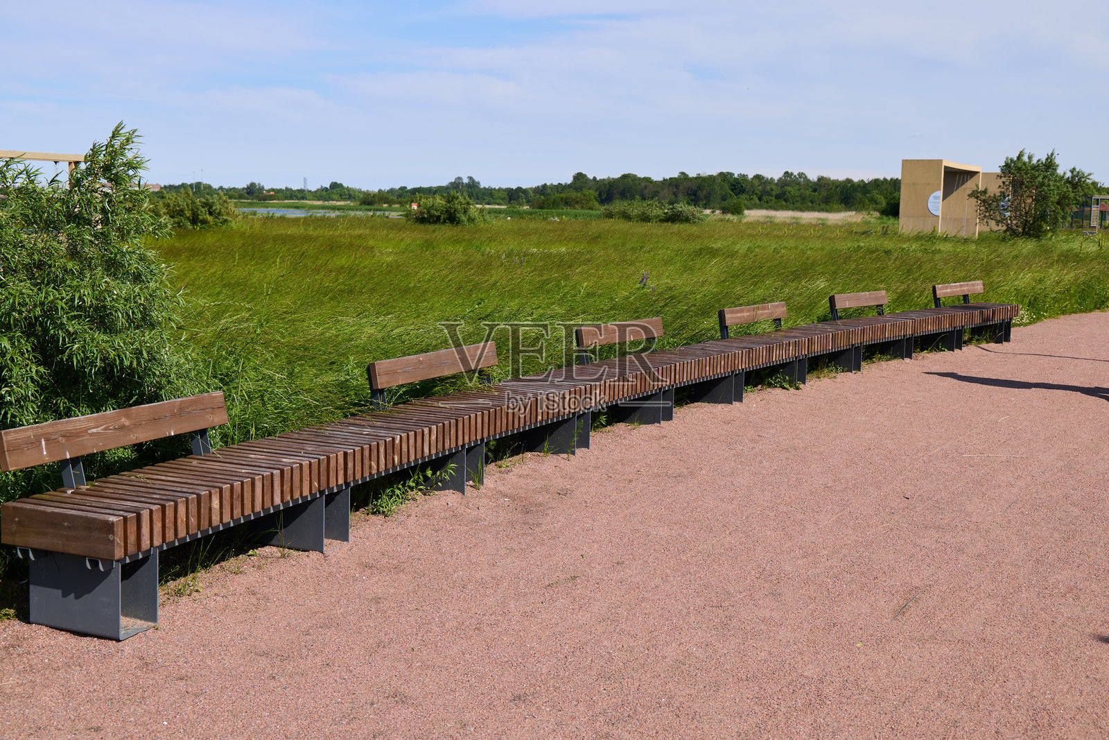 曲线木长椅组合，置于宜人且风景如画的户外环境中，供人放松和享受照片摄影图片