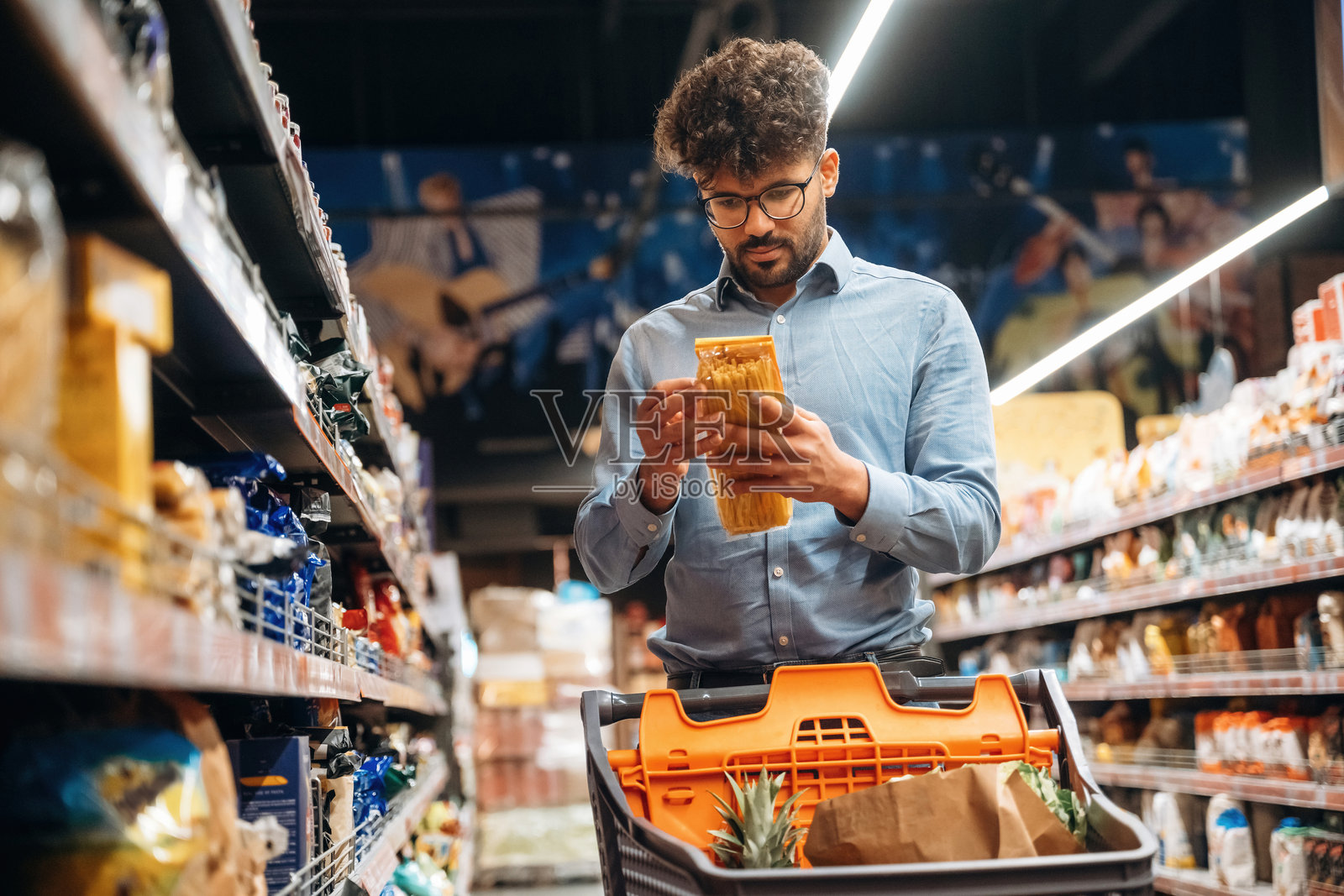 寻找餐点。男子在杂货店里。照片摄影图片