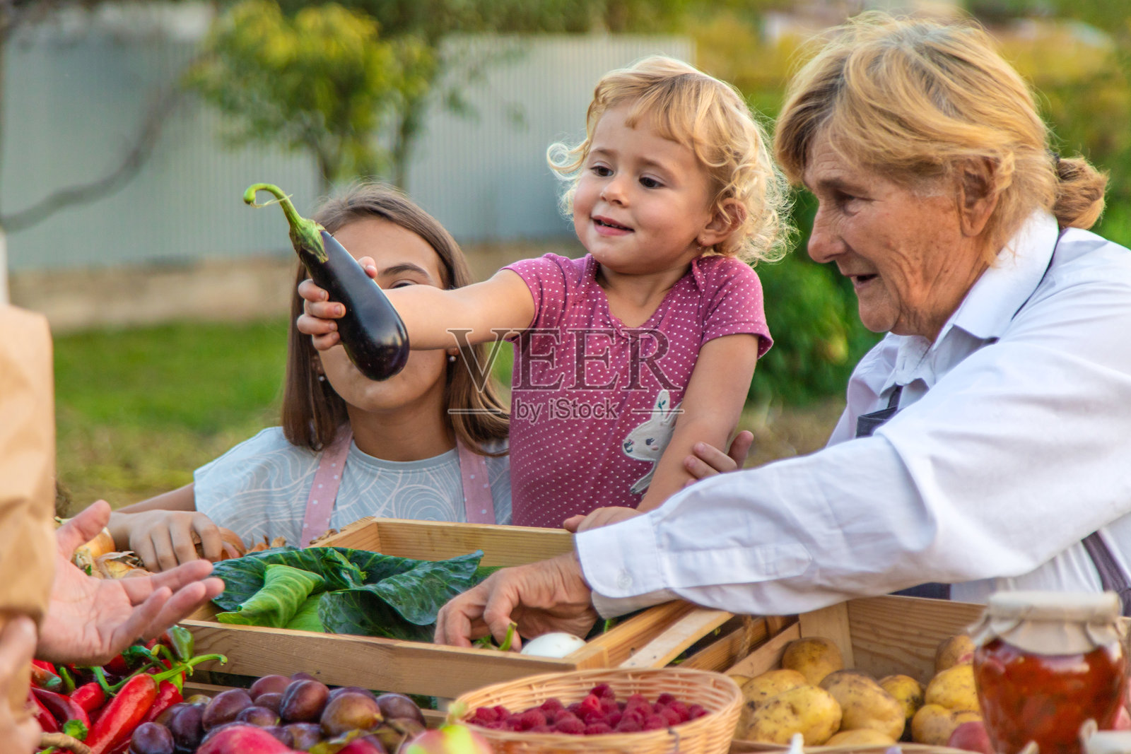 祖母和孙女在农贸市场出售蔬菜和水果。选择性对焦。照片摄影图片
