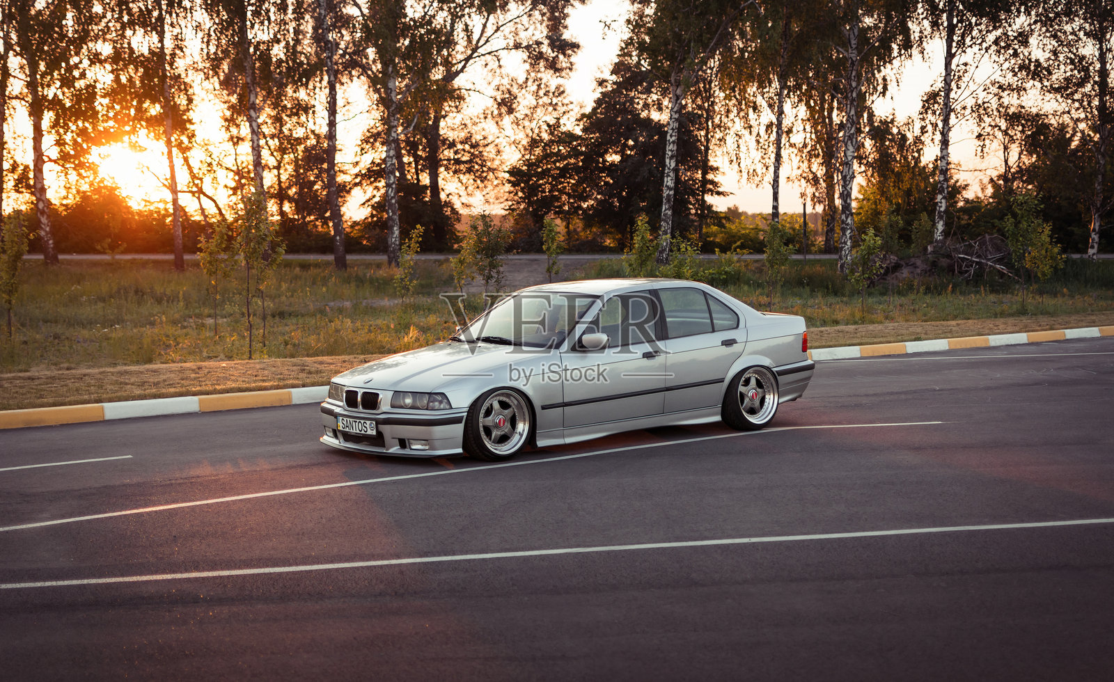 日落时分停在停车场的宝马3系E36轿车。照片摄影图片