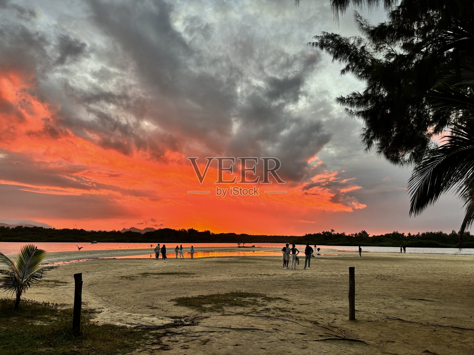 热带海滩五彩斑斓的天空、沙滩、日落光线和阳光。宁静的风景，地平线上的棕榈树和宁静的水面。浪漫的情侣在海边旅游。异国情调的海岸自然。宁静的夏日岛屿。照片摄影图片