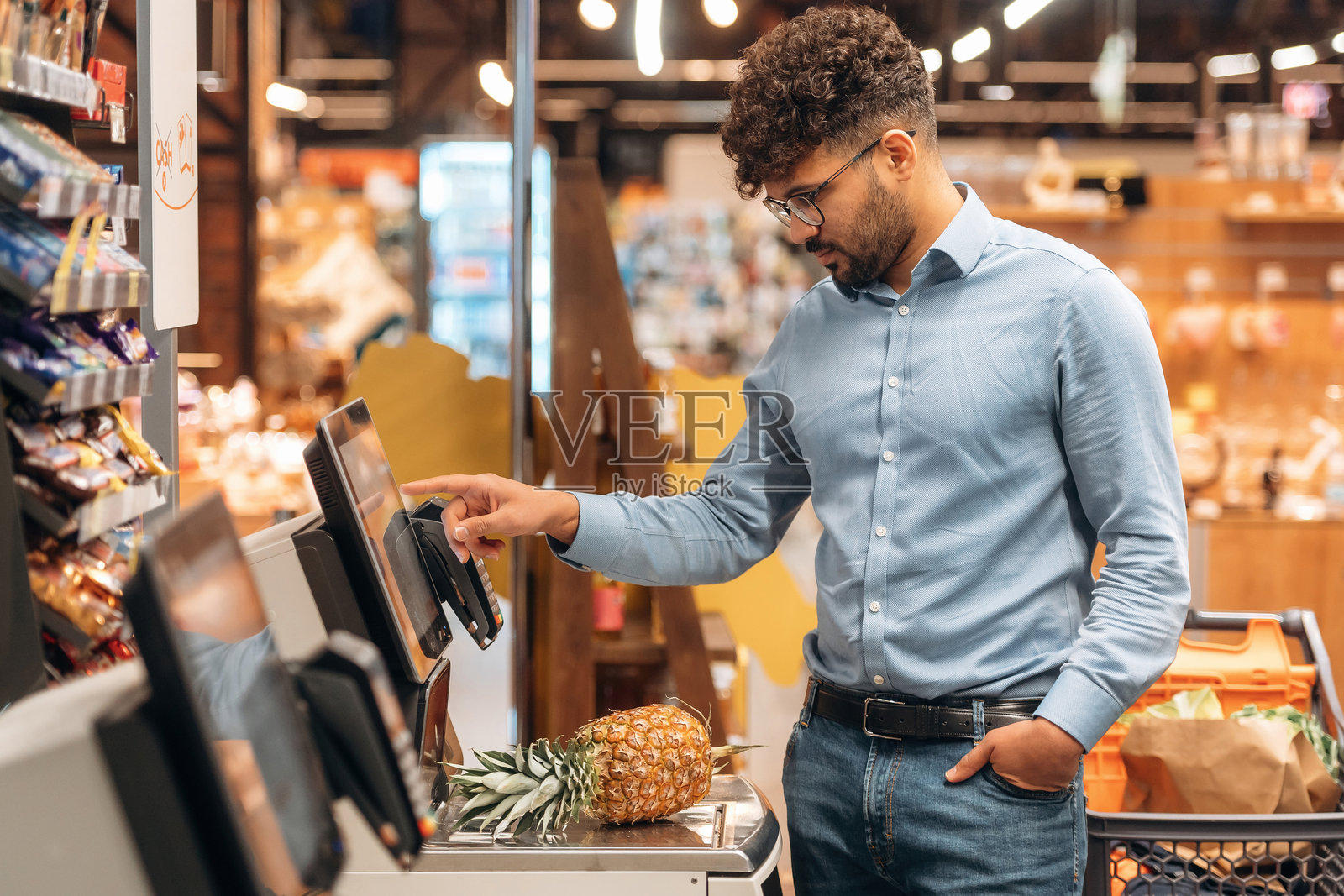 正面视角。男子在杂货店内。照片摄影图片