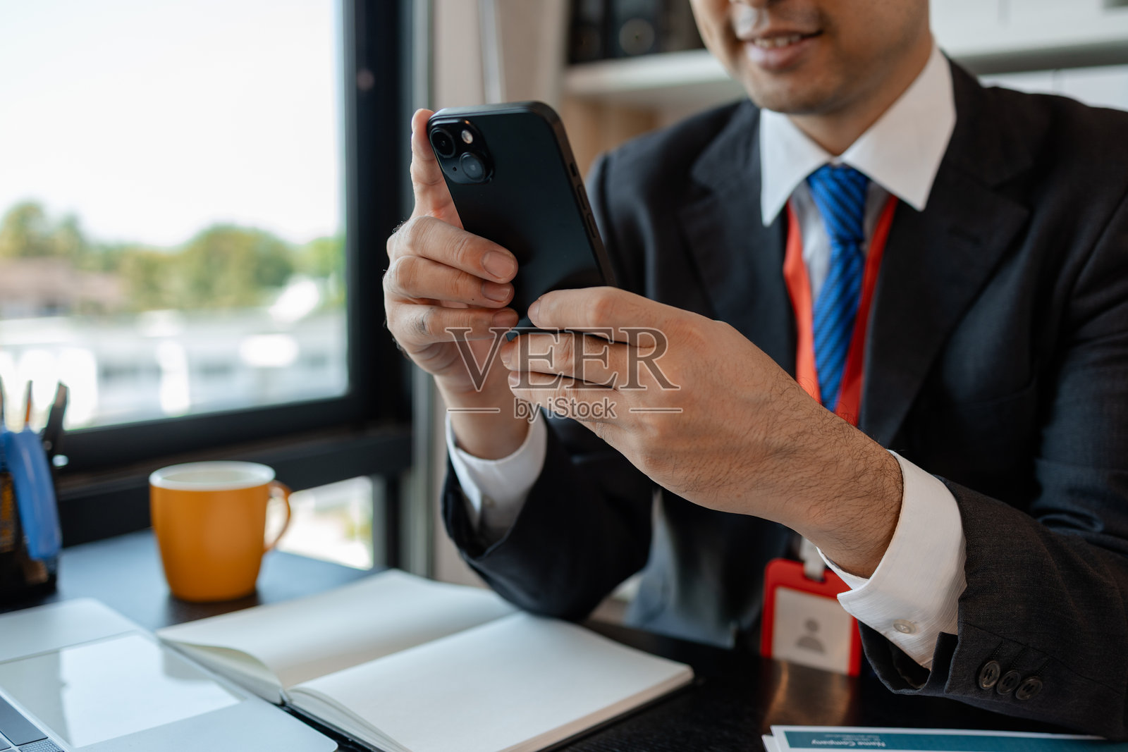 一位商人与外国公司合作，使用智能手机帮助发送和接收信息，市场经理通过智能手机将统计信息发送给财务部门。照片摄影图片