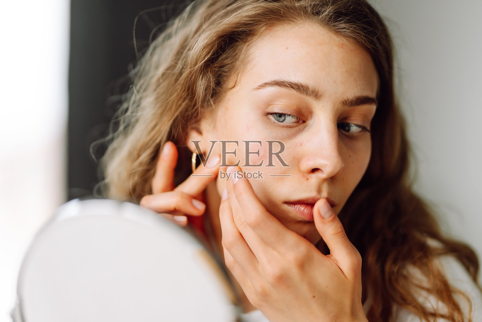 一位美丽的女性正在触摸自己的皮肤，检查皮肤上的皮疹。照片摄影图片