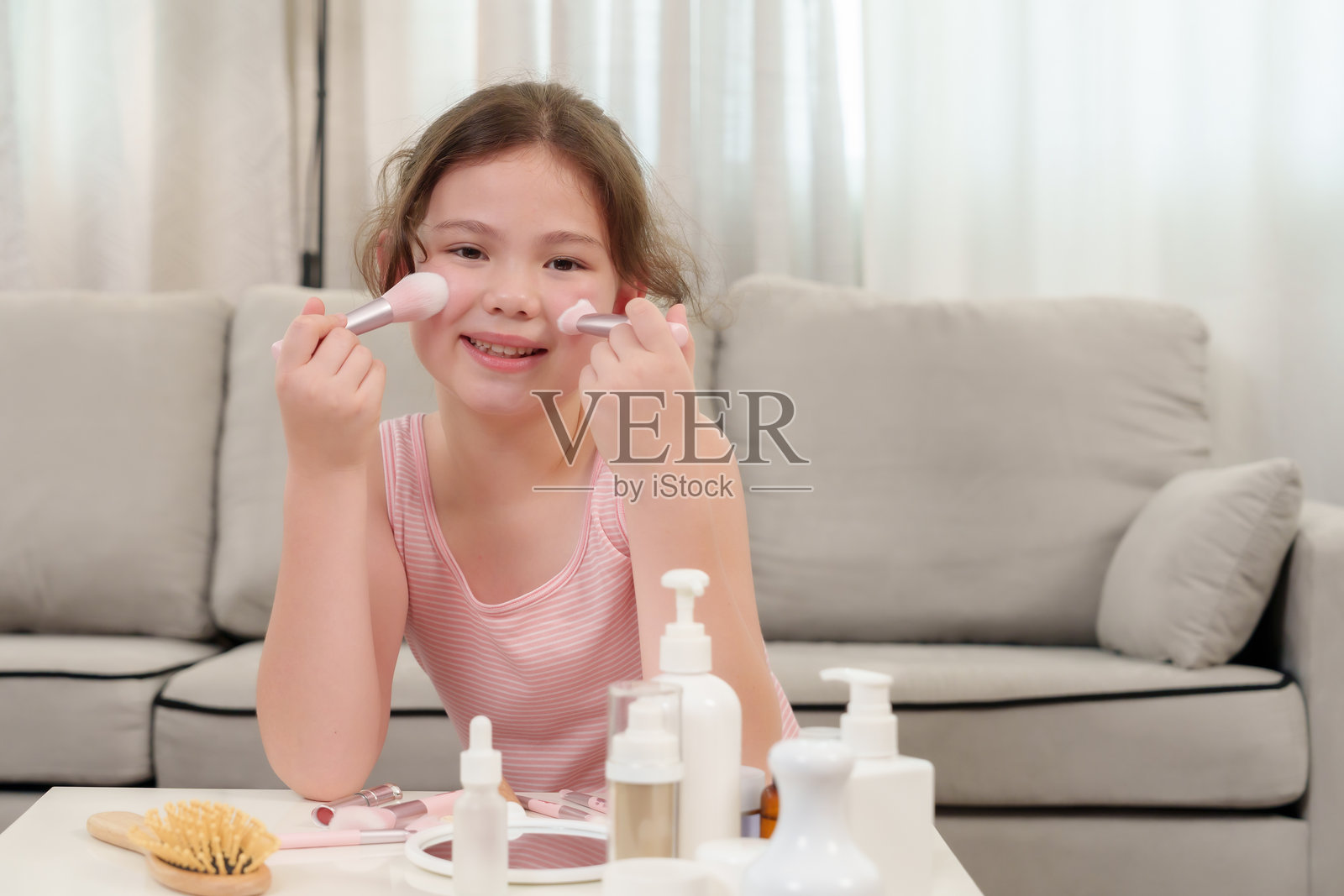 年轻的亚洲女孩在家中微笑着自己化妆，享受美丽探索的快乐时刻，展现独立，学习自我护理，自信的表情，积极而快乐。照片摄影图片