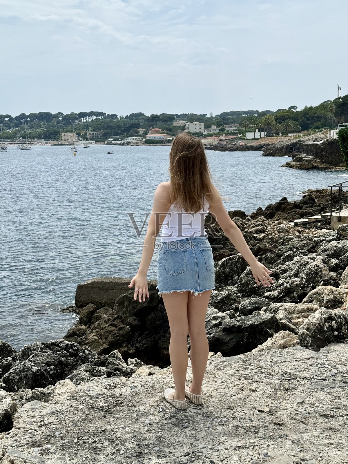 一位女性在海边张开双臂，静静地感受感激与反思的时刻。照片摄影图片