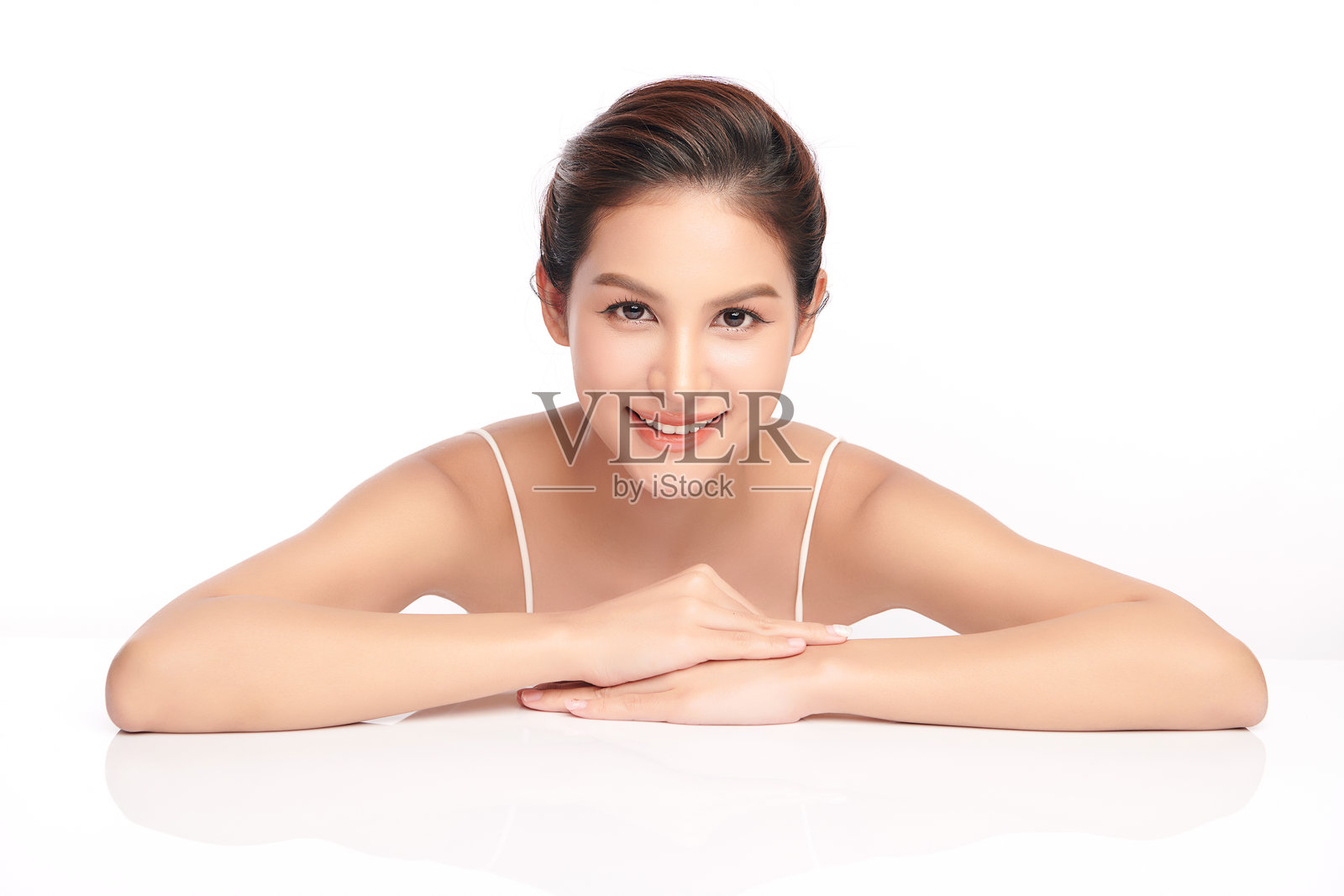 一位年轻美丽的亚洲女性，皮肤洁净清新，背景为白色。护肤、面部护理、美容学、美丽和水疗。优雅的亚洲女性肖像。照片摄影图片