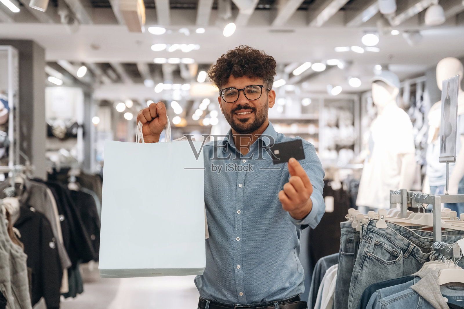 顾客在服装店使用信用卡付款。照片摄影图片