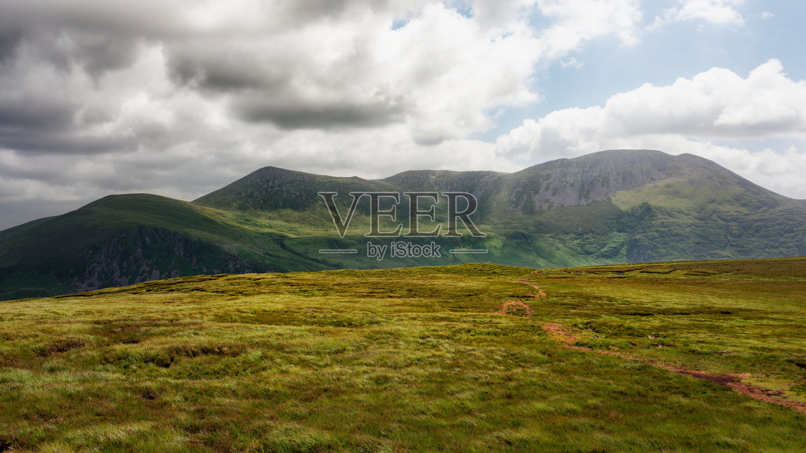 一片郁郁葱葱的山谷，四周环绕着壮丽的山脉。美丽的景色。照片摄影图片