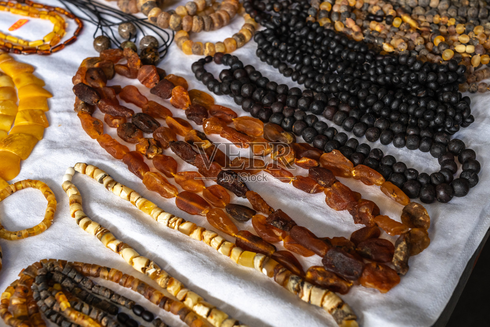 琥珀石市场，抛光的橙色宝石特写，自然波罗的海琥珀珠宝店照片摄影图片