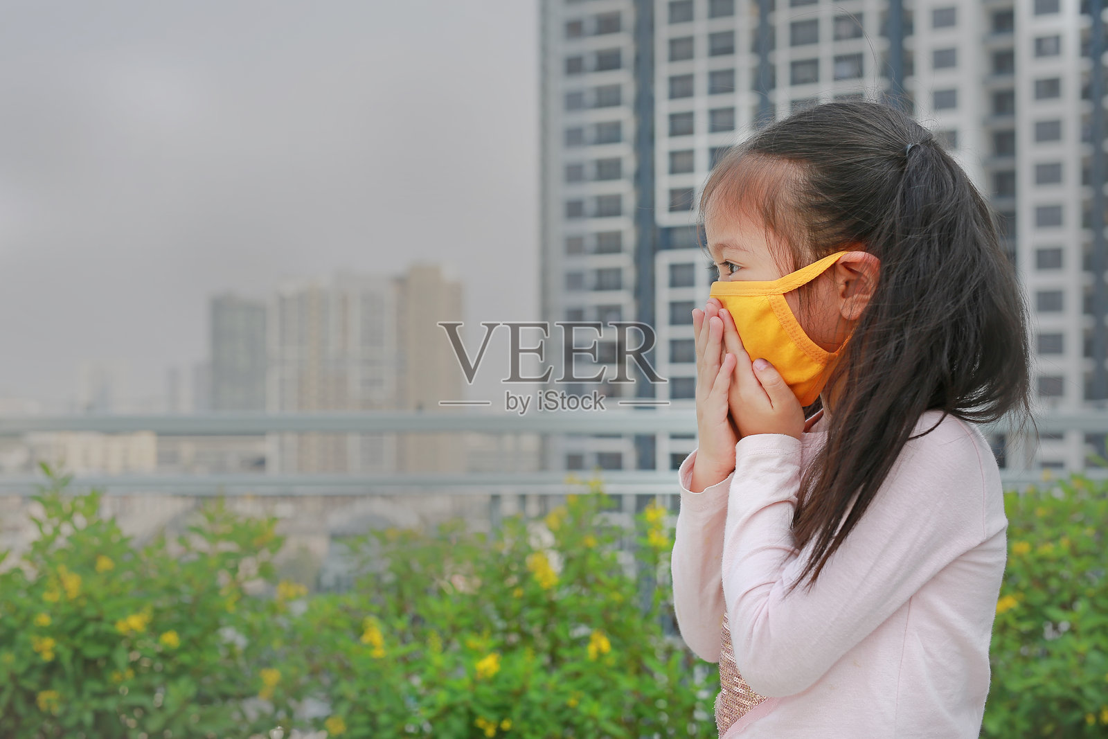 亚洲小女孩在泰国曼谷市佩戴防护口罩以抵御PM 2.5空气污染。照片摄影图片