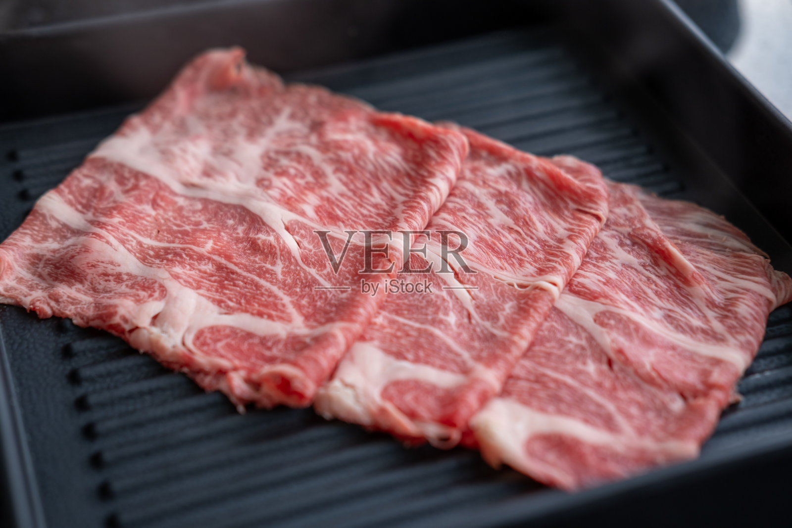 切好的生肉特写，整齐地摆放在盘子里，准备放入火锅中烹饪照片摄影图片