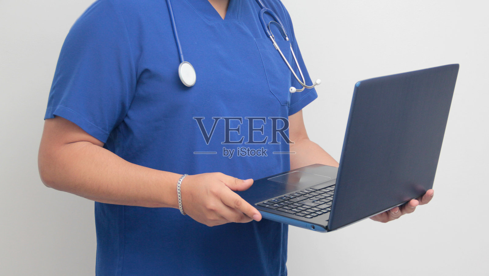 拉丁裔男性专科医生使用笔记本电脑进行视频咨询、搜索信息和学习。照片摄影图片