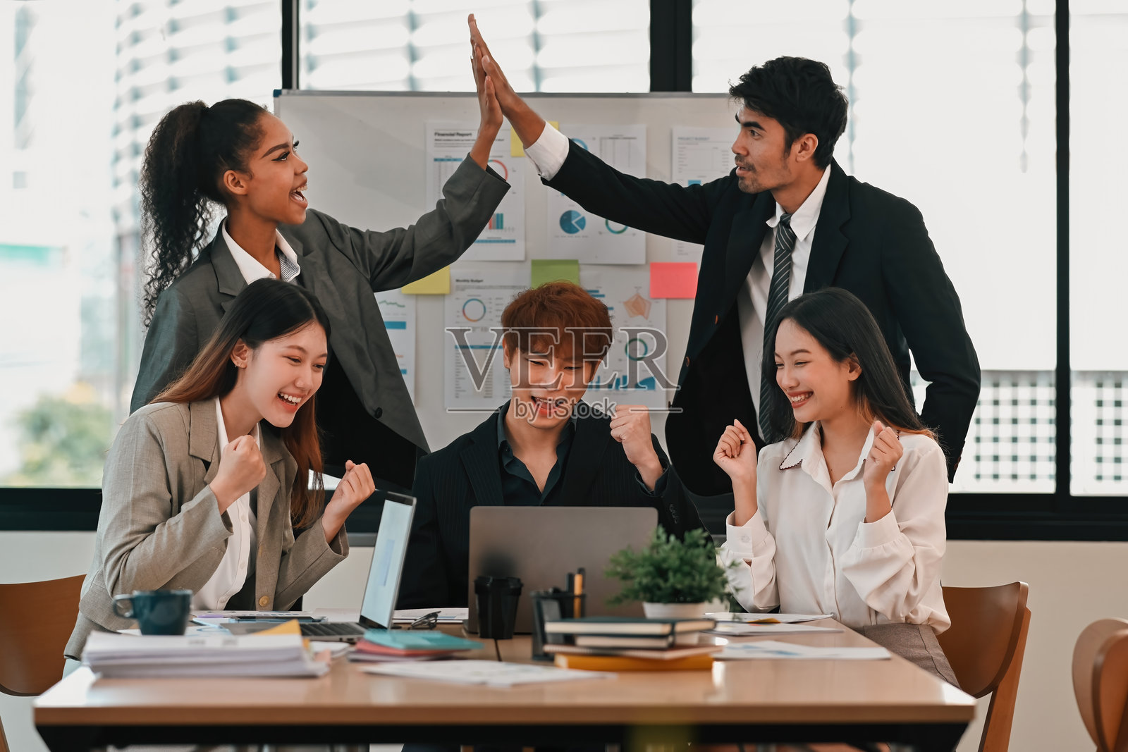 快乐的多元文化商业团队在现代办公室庆祝成功的项目照片摄影图片