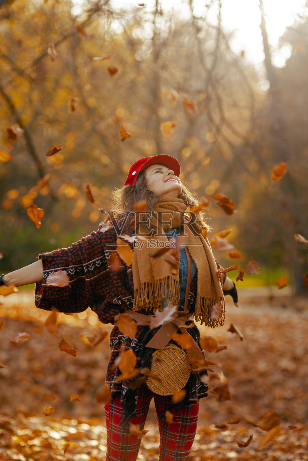 微笑的时尚女性戴着红色帽子，欢欣鼓舞照片摄影图片