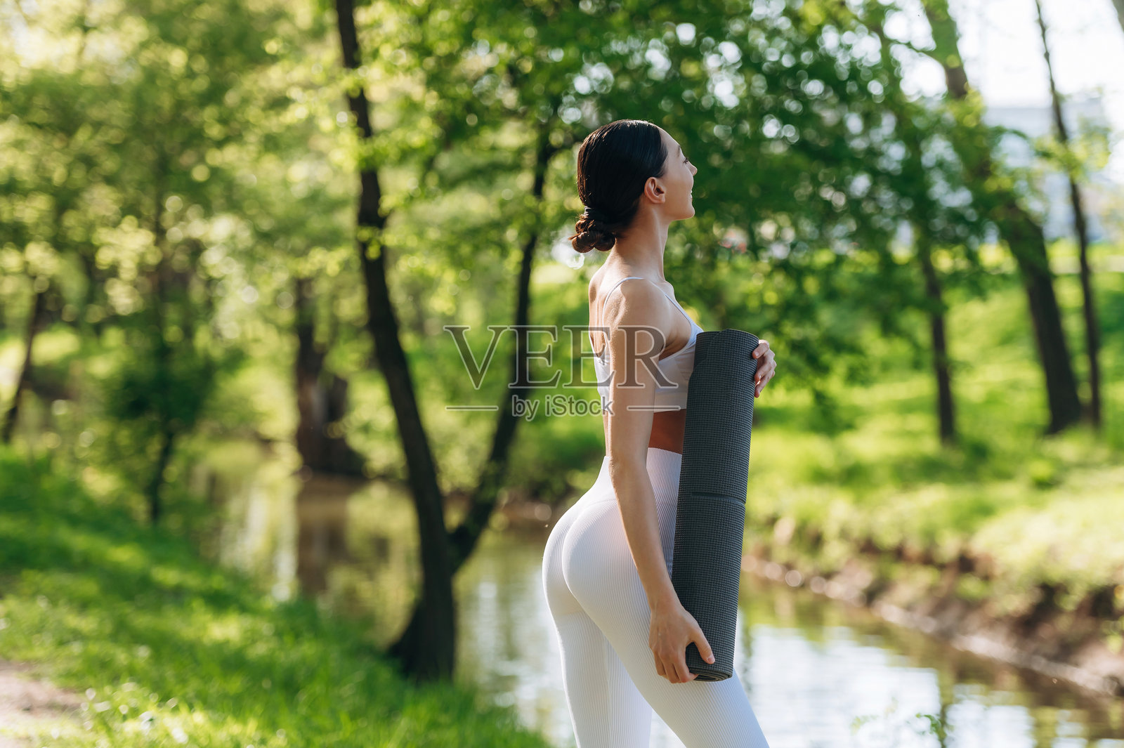 在河边。美丽的健身瑜伽女性在户外，享受着迷人的自然风光。照片摄影图片