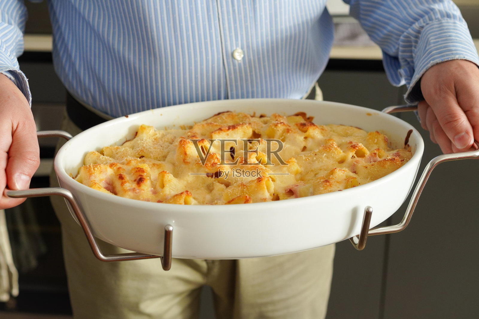 一位中年意大利男子为家人端上自己制作的意大利面照片摄影图片