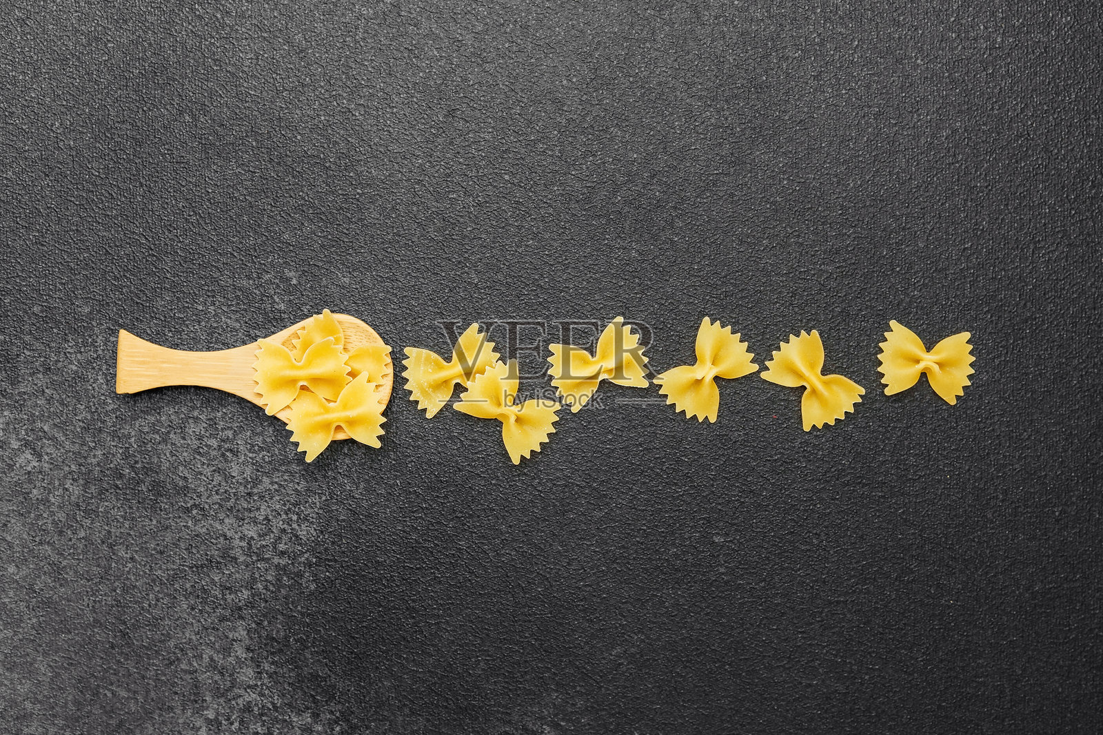 创意展示的蝴蝶面意大利面摆放在深色表面上照片摄影图片