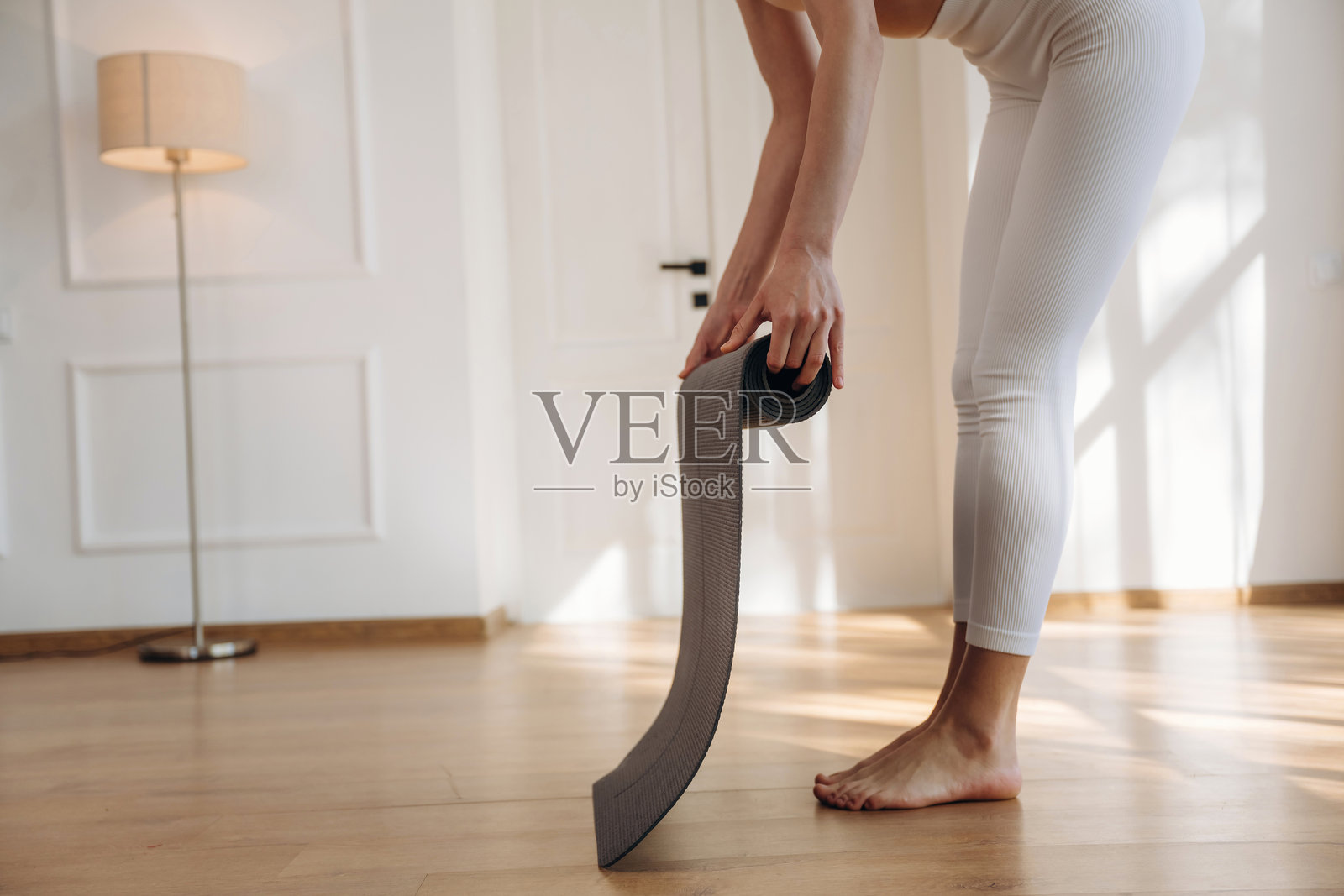 准备瑜伽垫，特写镜头展示在家练习的女性照片摄影图片