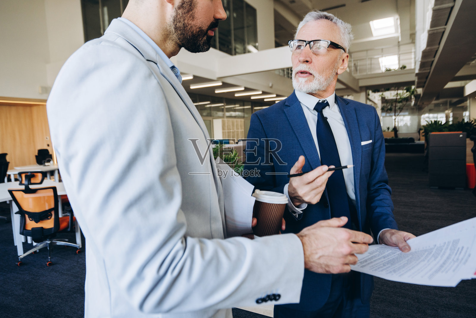 首席执行官与中年经理在现代办公大楼内讨论合同照片摄影图片
