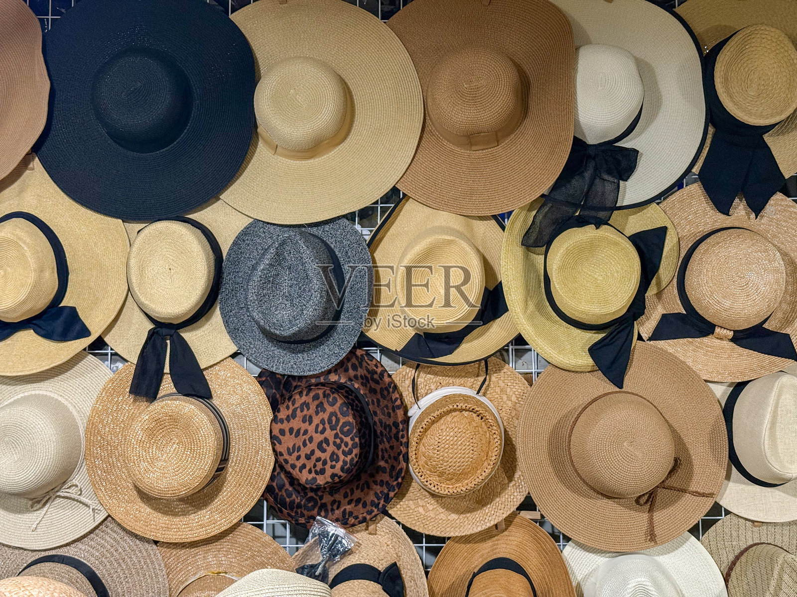 在蝉市场的墙架上展示的各种编织草帽出售照片摄影图片