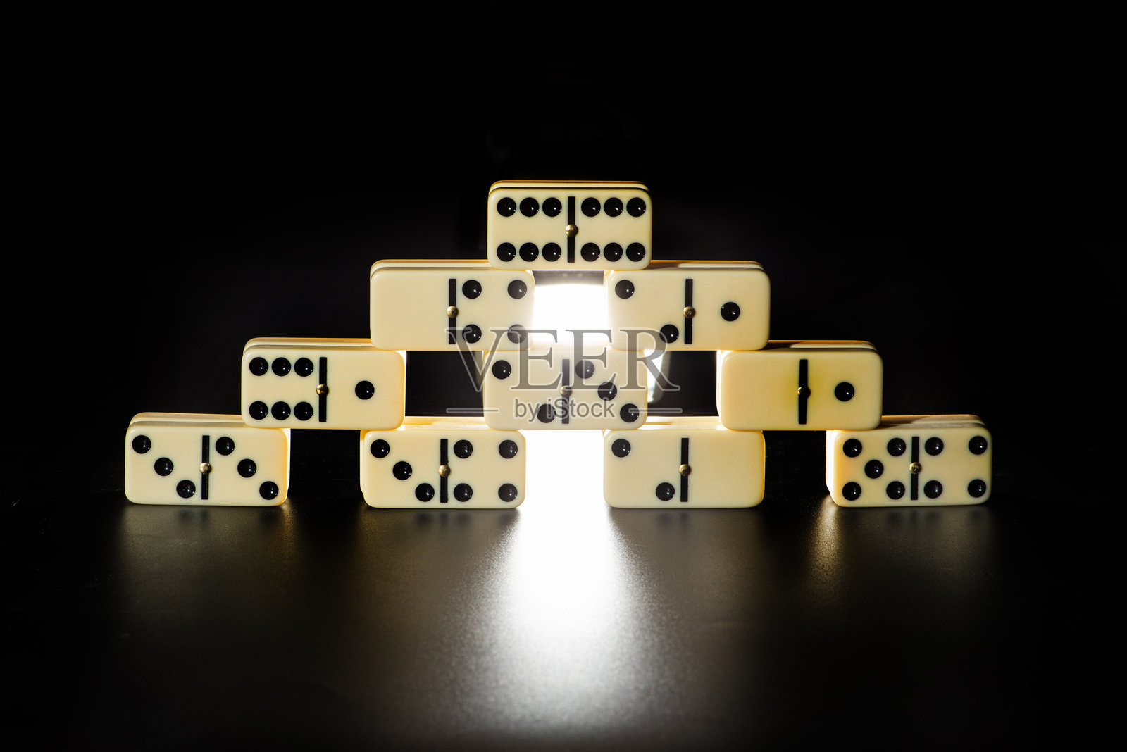 多米诺骨牌，美丽的白色骨牌小心地放置在黑色表面上，选择性对焦。照片摄影图片