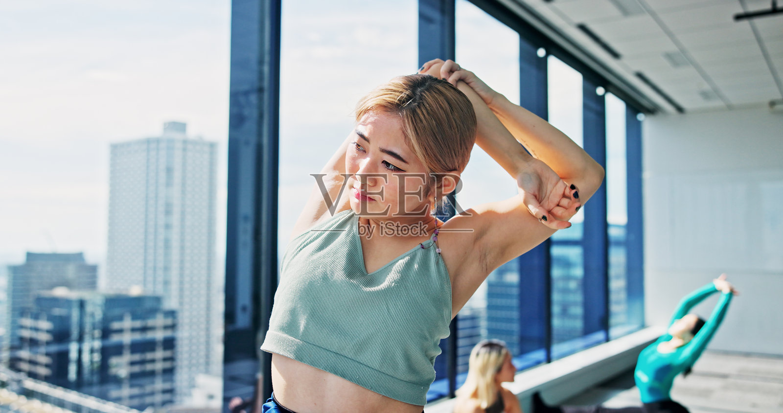 健身，日本女性在舞蹈工作室中伸展手臂进行练习、训练和芭蕾舞编排。热身、肌肉柔韧性以及为公司、剧院和表演艺术学校的舞者。照片摄影图片