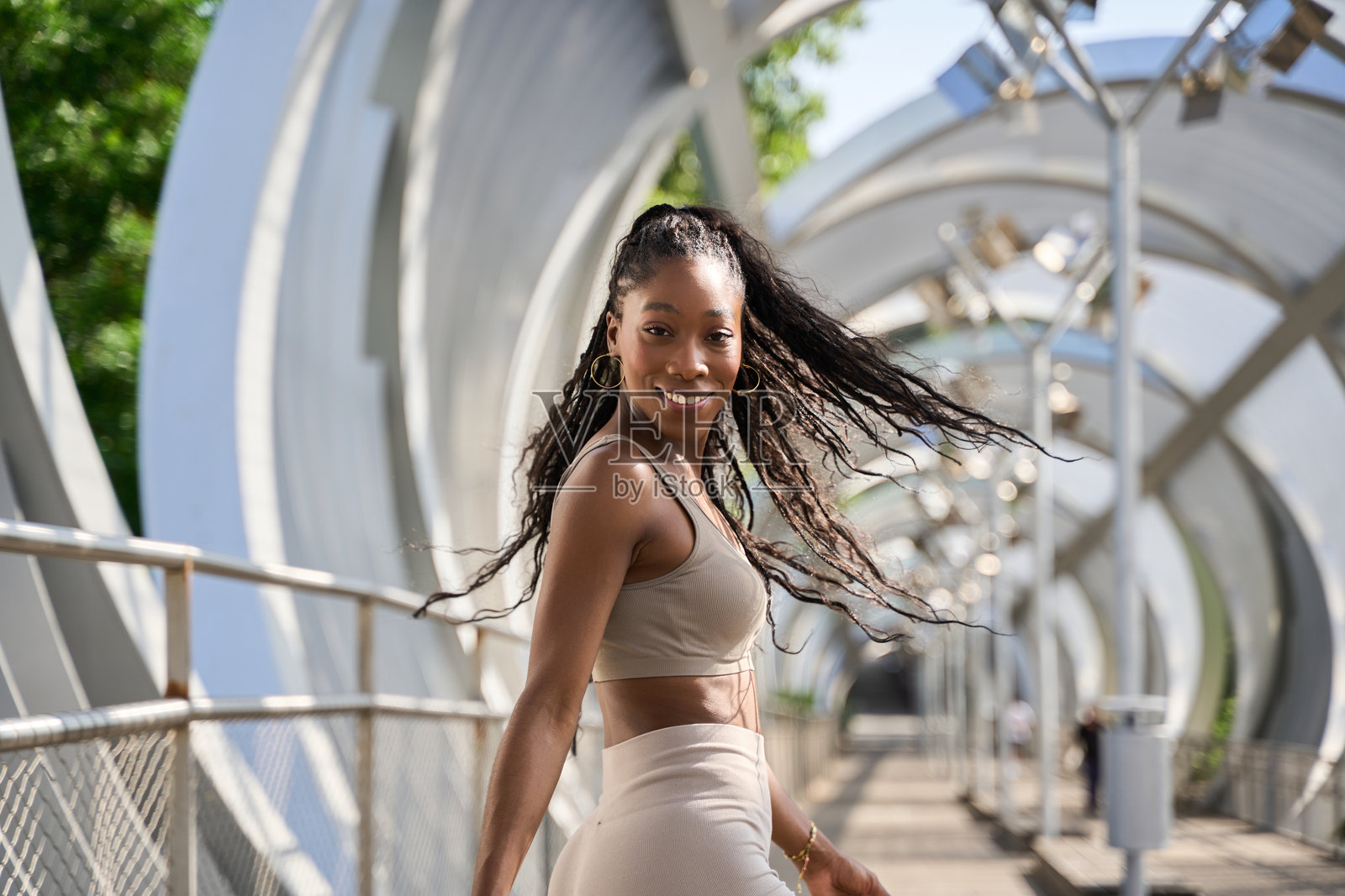 年轻的运动女性走在现代桥上照片摄影图片