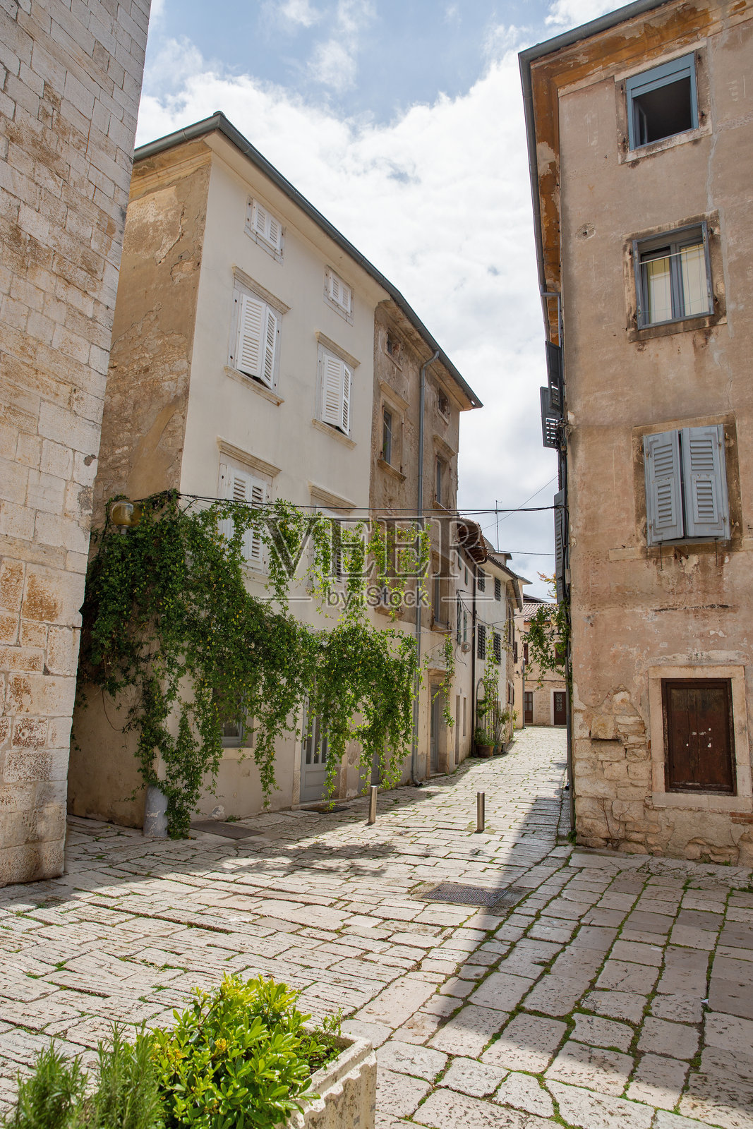克罗地亚波雷奇的风景如画的狭窄街道，绿植环绕。照片摄影图片