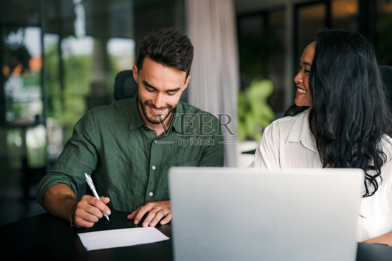 多种族同事在办公室内讨论创业项目并微笑，工作日的场景照片摄影图片