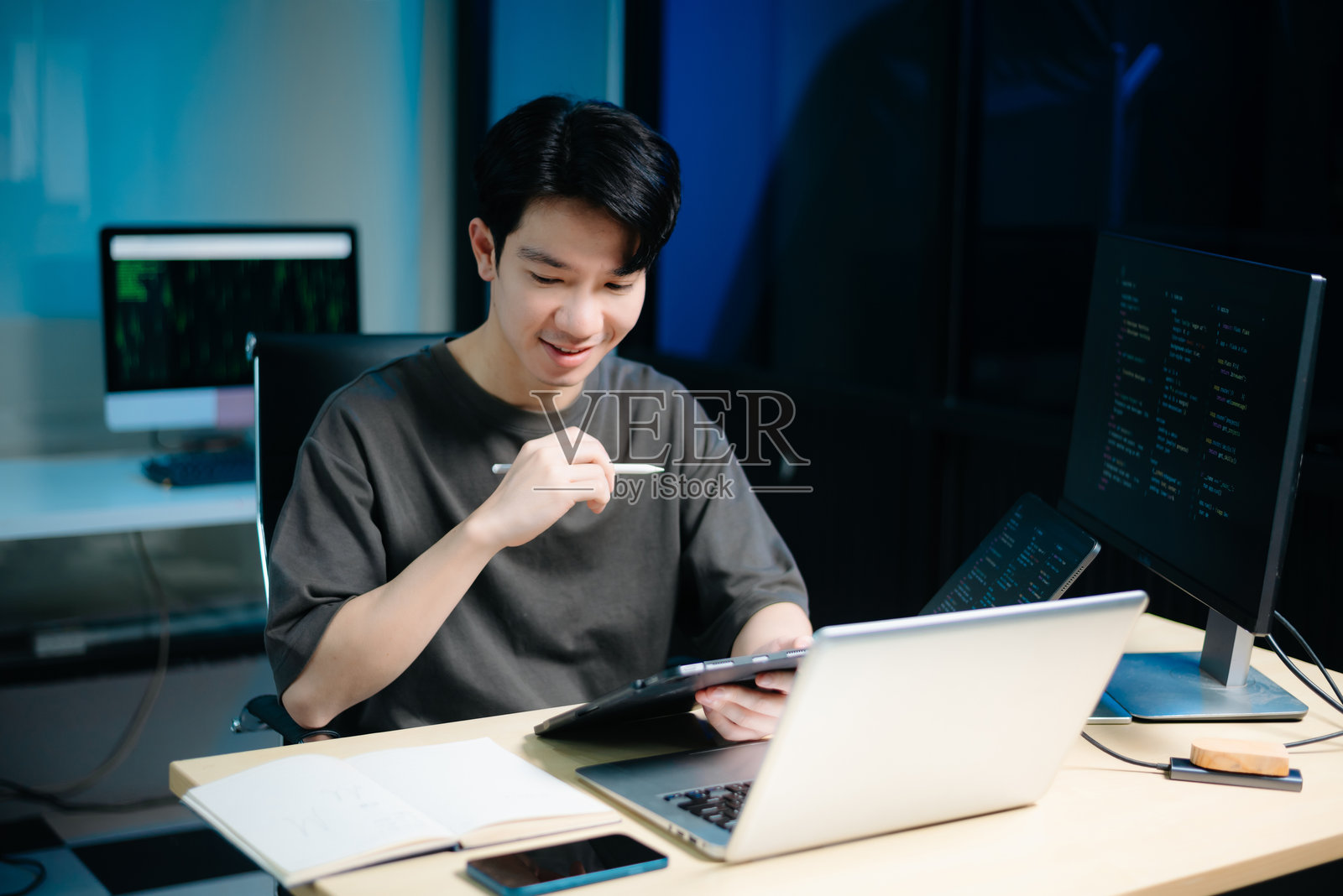 亚洲男性程序员在科技办公室使用平板电脑、笔记本电脑和台式电脑。编程，软件开发照片摄影图片