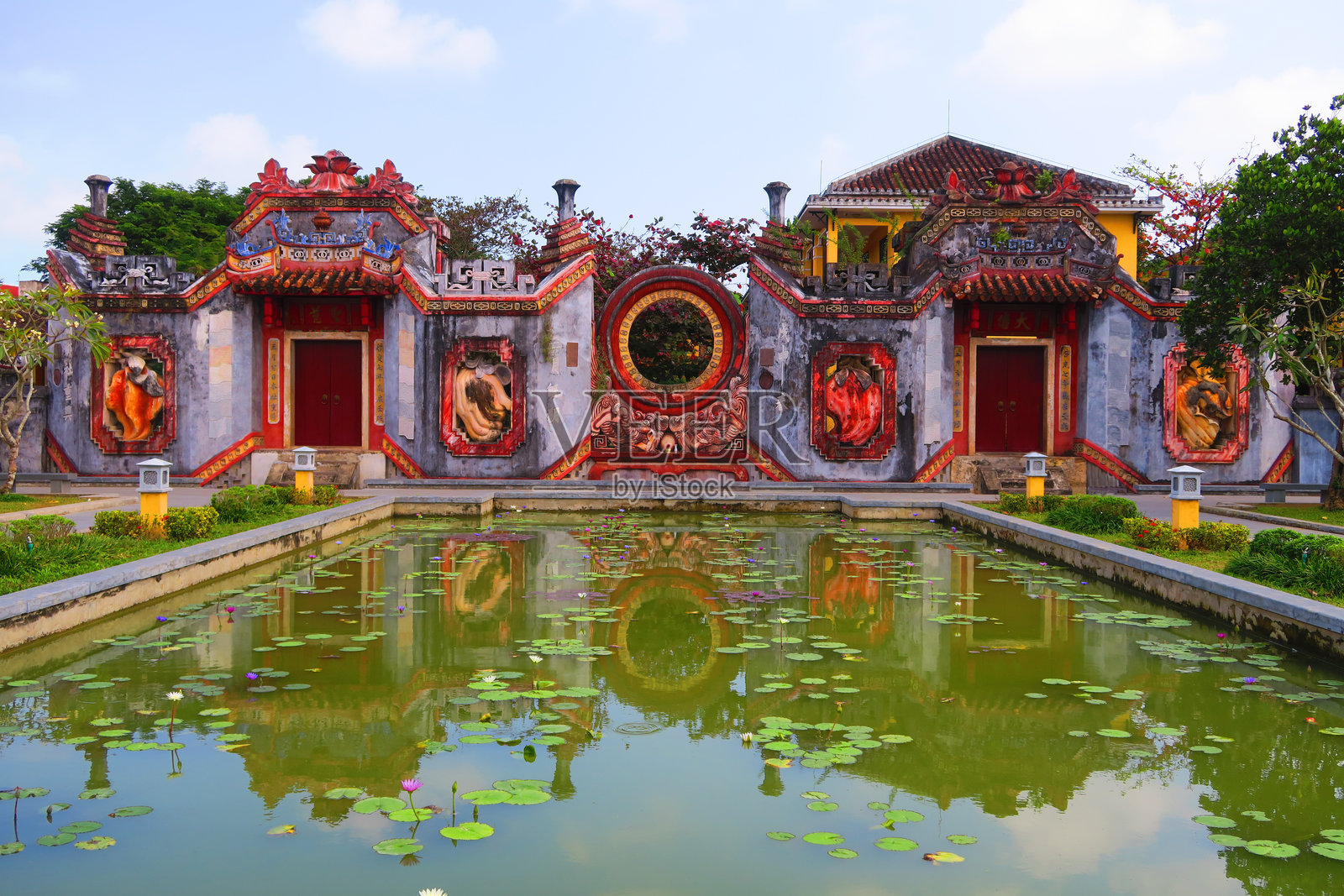 在会安市，华丽的门在宁静的池塘中倒影。照片摄影图片