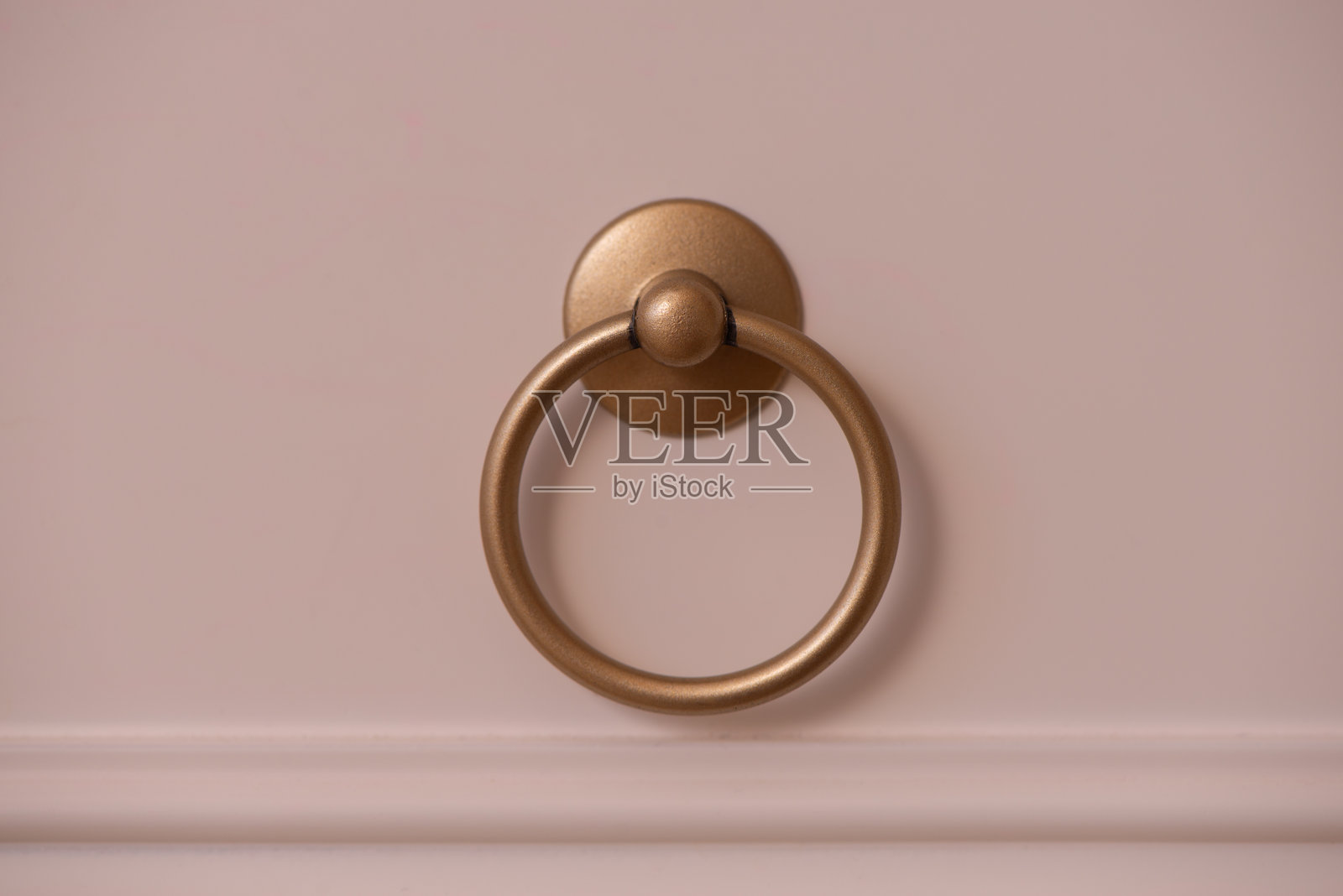 简约的黄铜抽屉拉手放在浅色表面上。照片摄影图片