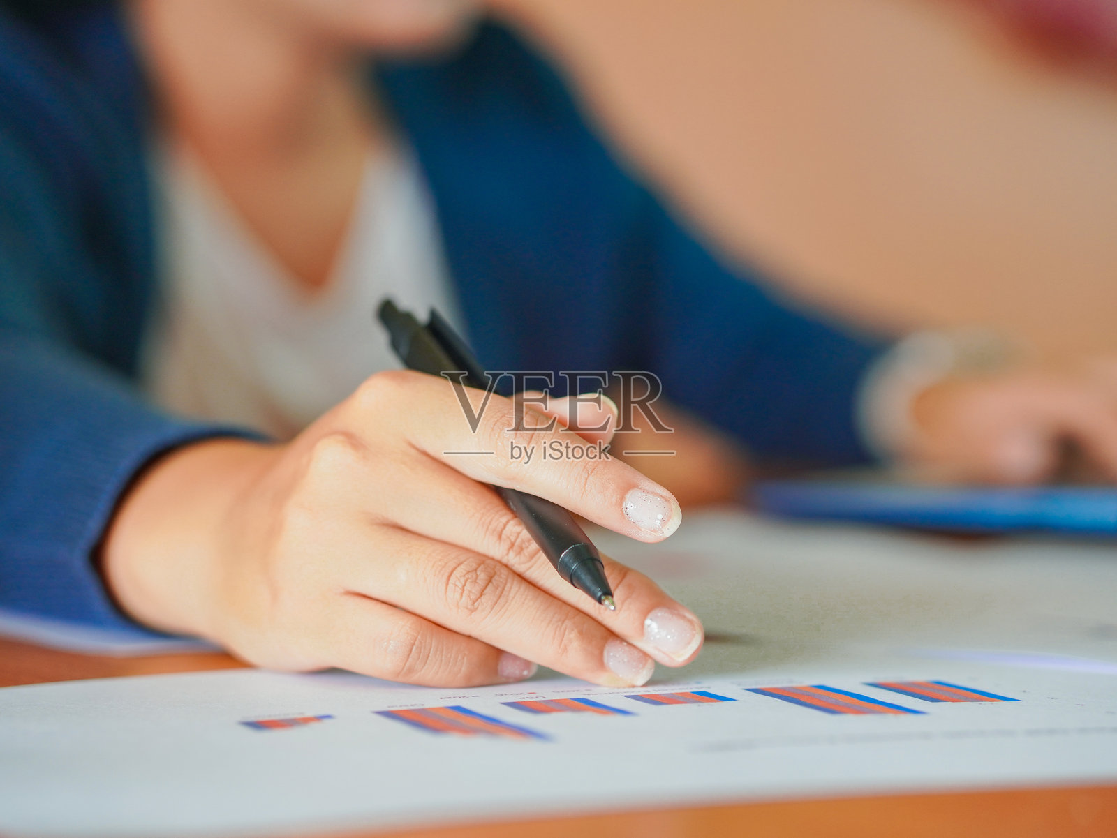 商务女性分析经济和财务图表，特写员工手持笔与文件。远程工作技术概念。照片摄影图片